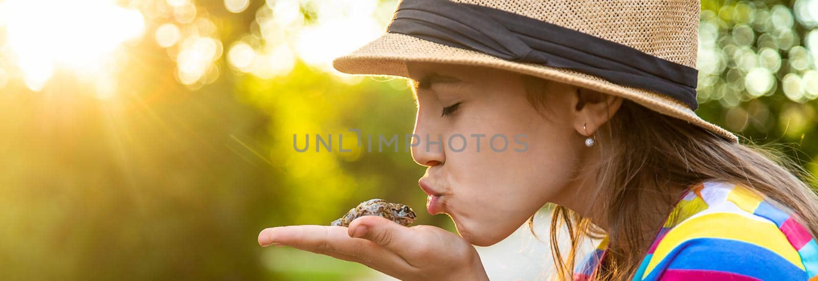 The child is playing with the frog. Selective focus. Kid.