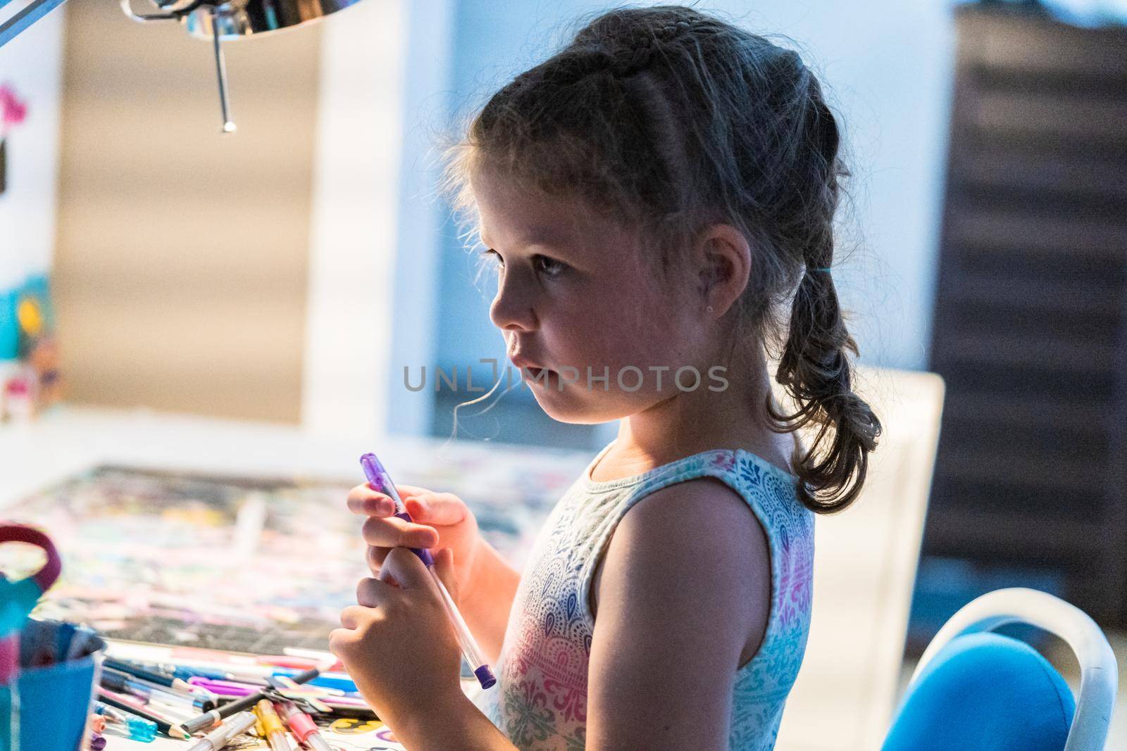 Little girl studying at home during the e-learning school.