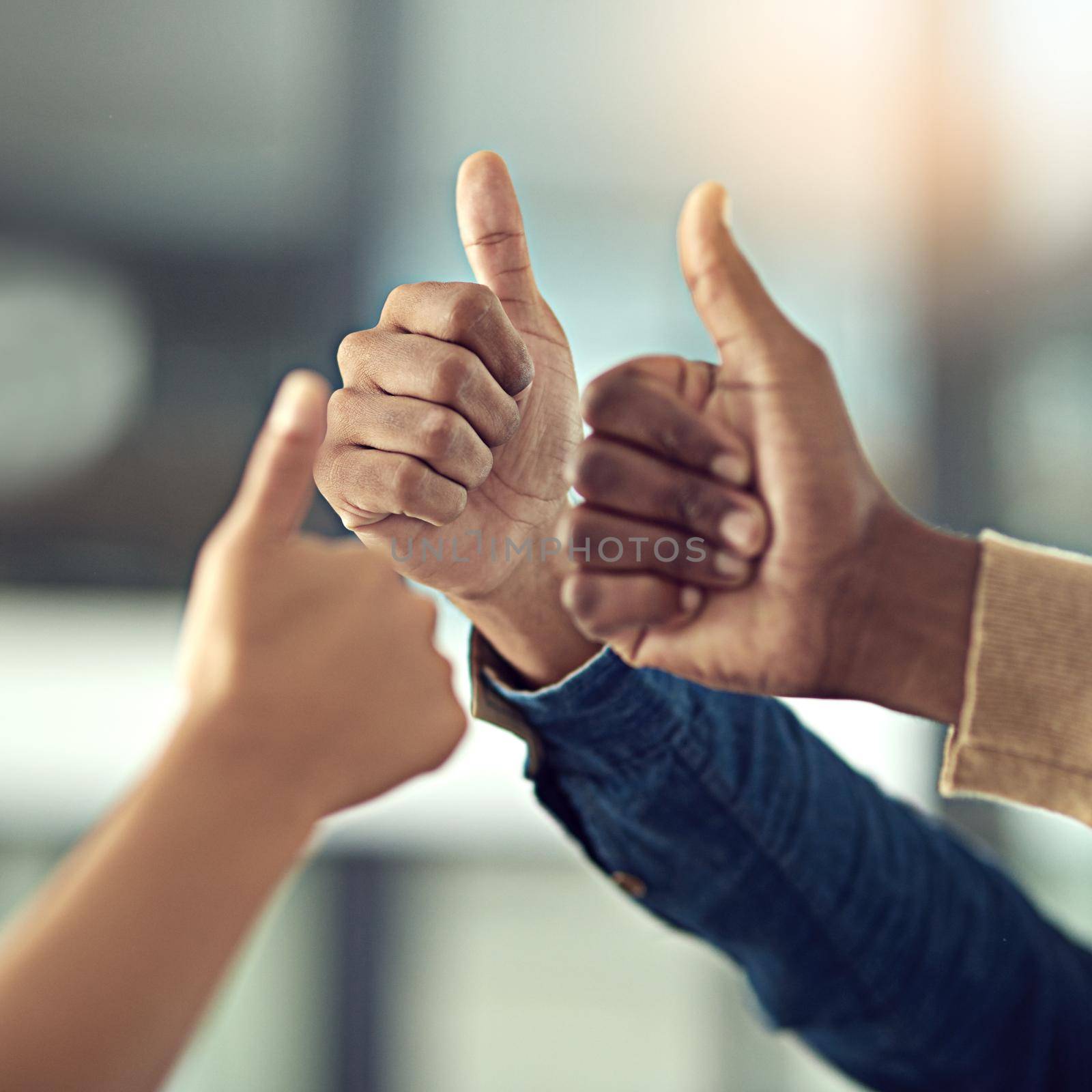 Keep up the exceptional work. Closeup shot of a group of businesspeople giving thumbs up together