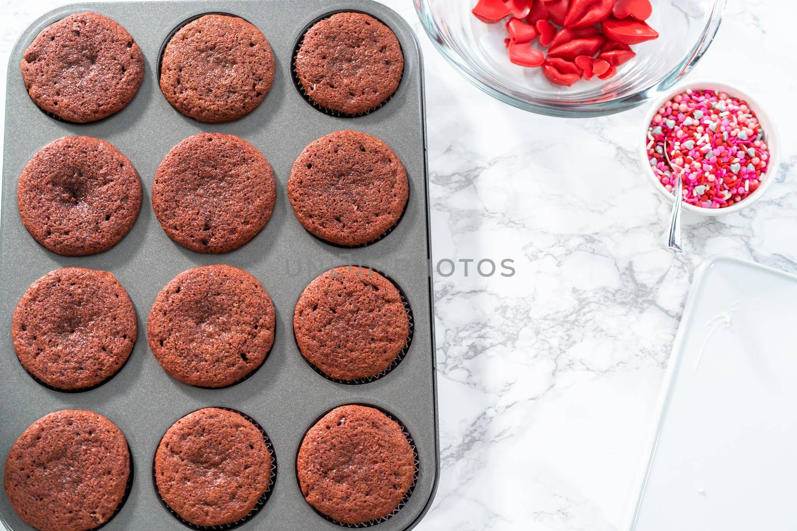 Cooling freshly baked red velvet cupcakes.
