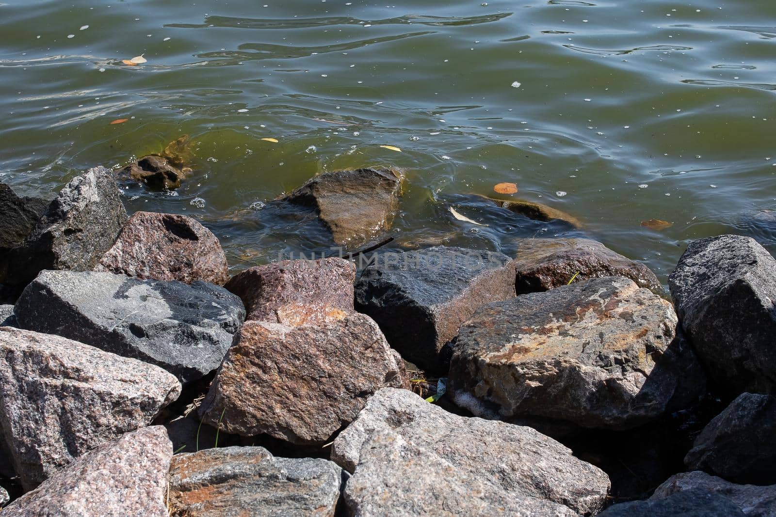Large gray stones on the shore with waves close up