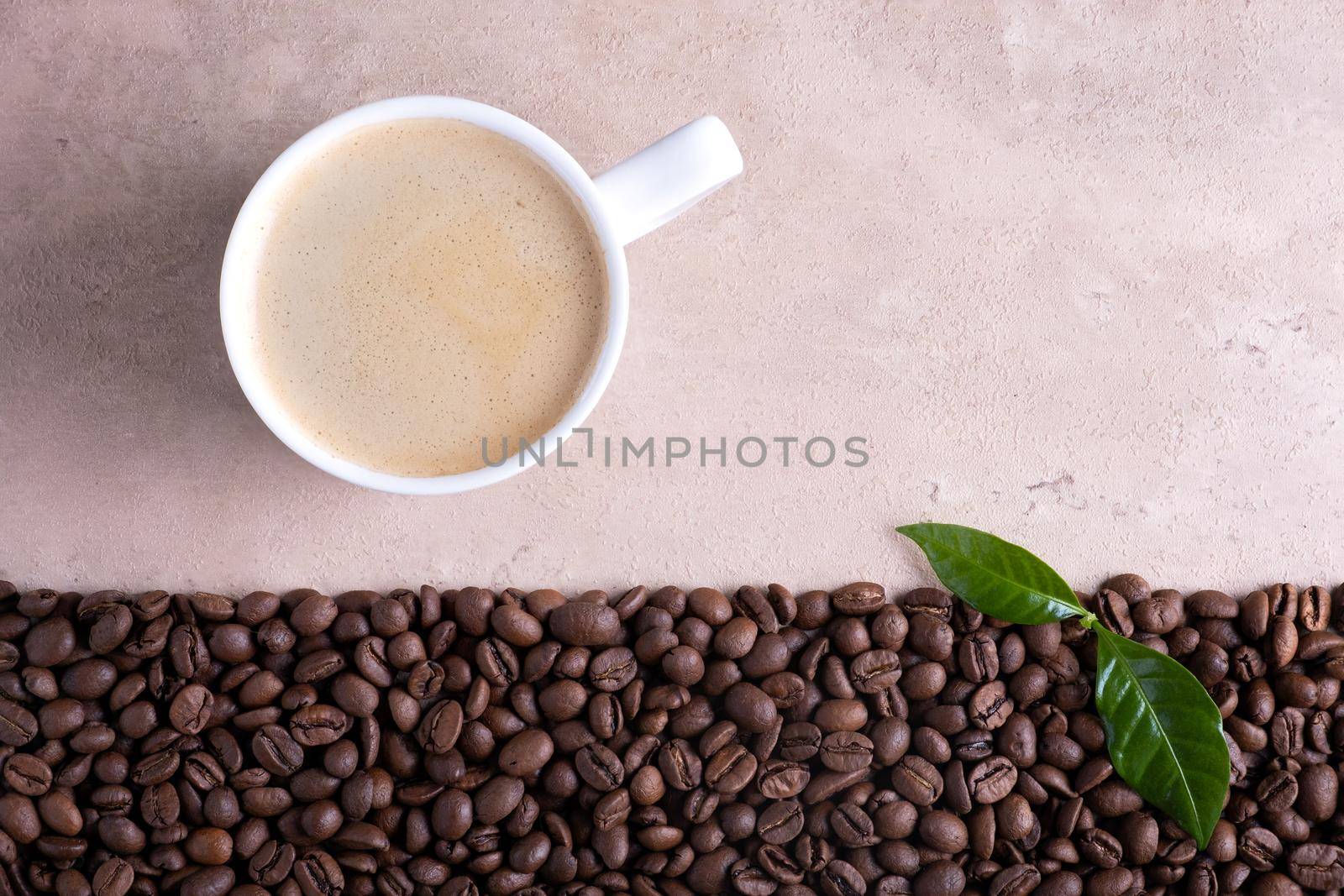 Top view with place for text roasted coffee beans border and cup of coffee on a light brown background.
