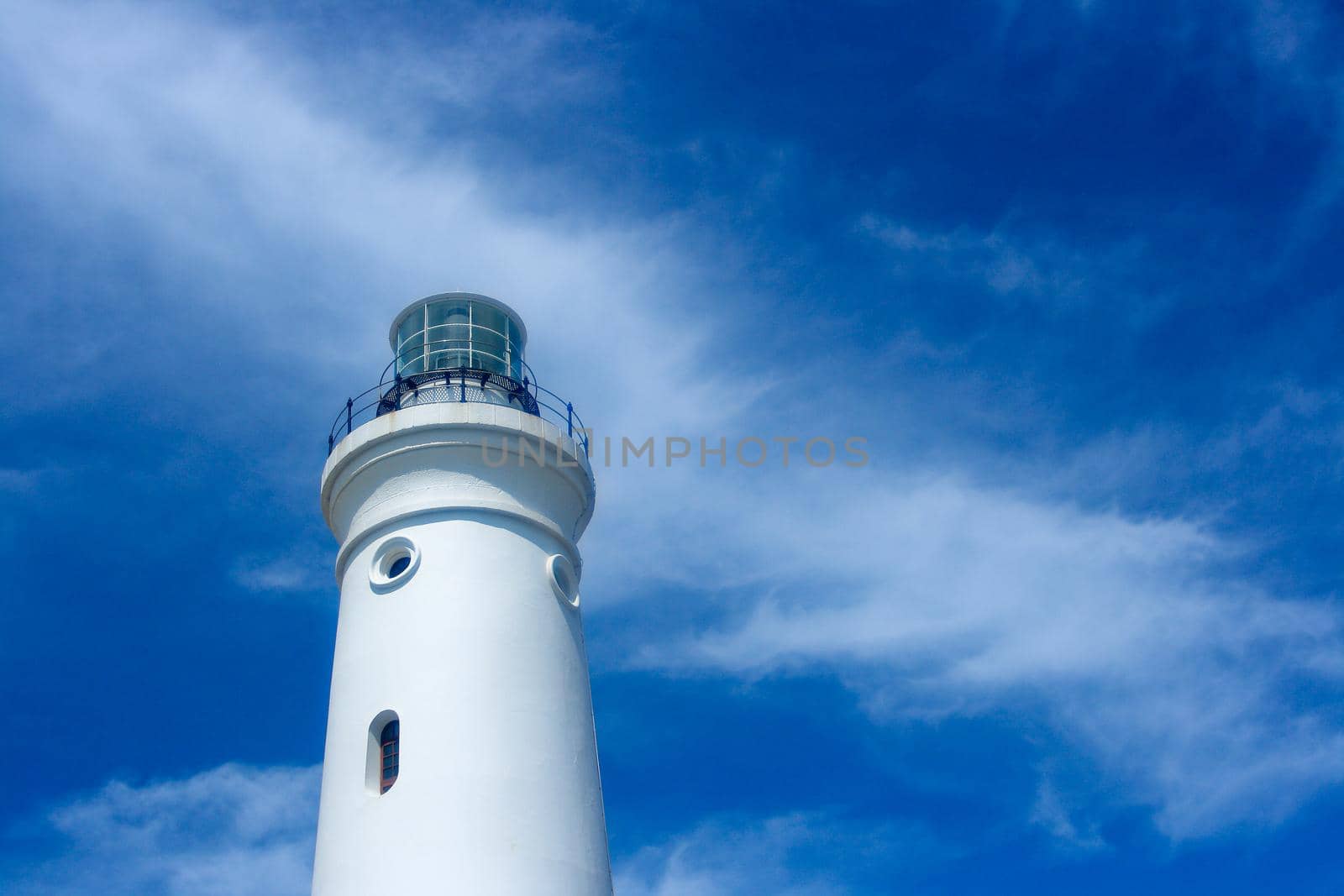 Bright white lighthouse tower at Cape St. Francis with cloudy blue sky, St. Francis Bay, South Africa