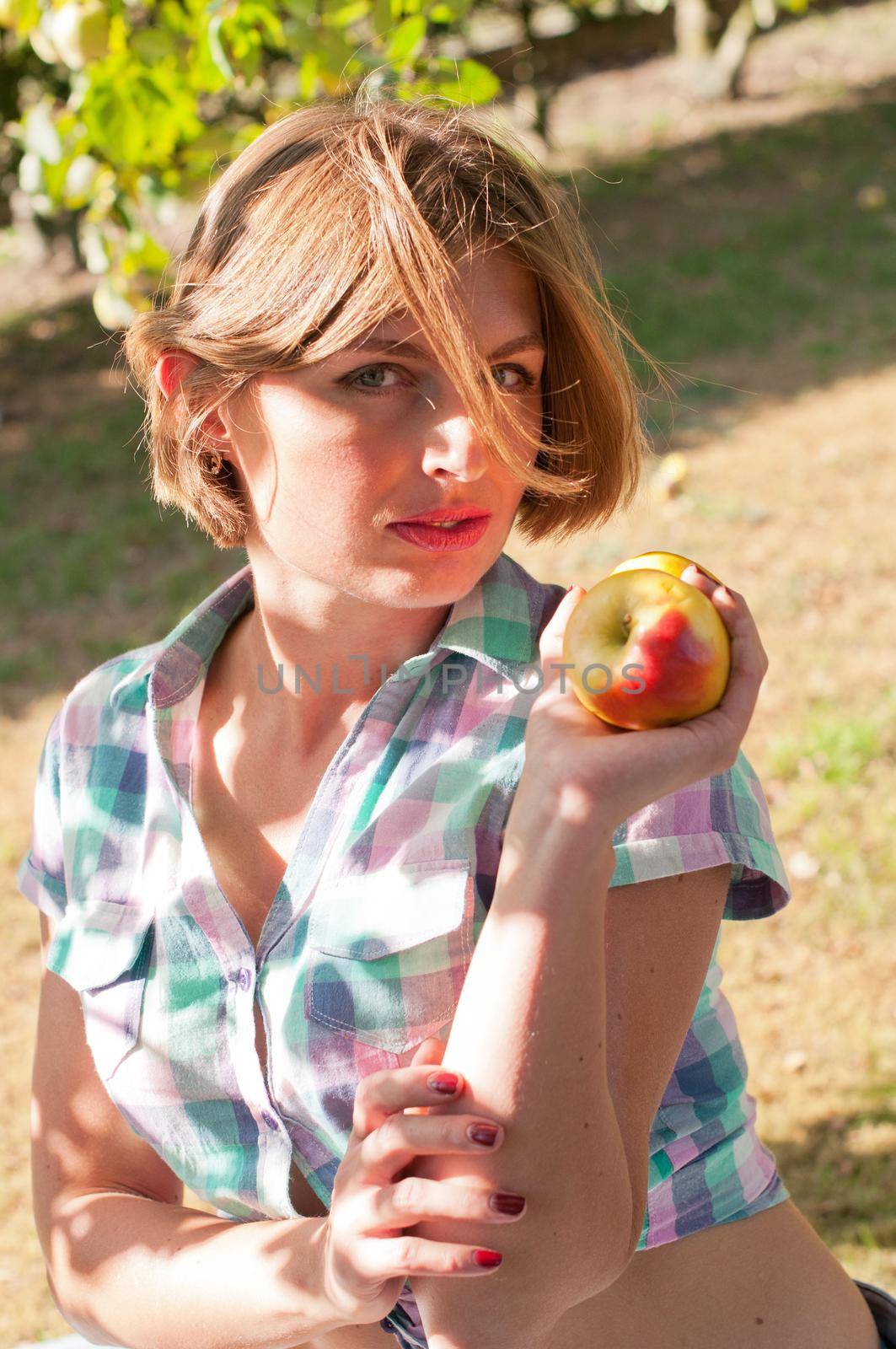 beautiful young caucasian girl in pin-up clothes, eat fresh apple on picnic, woman healthy lifestyle. High quality photo