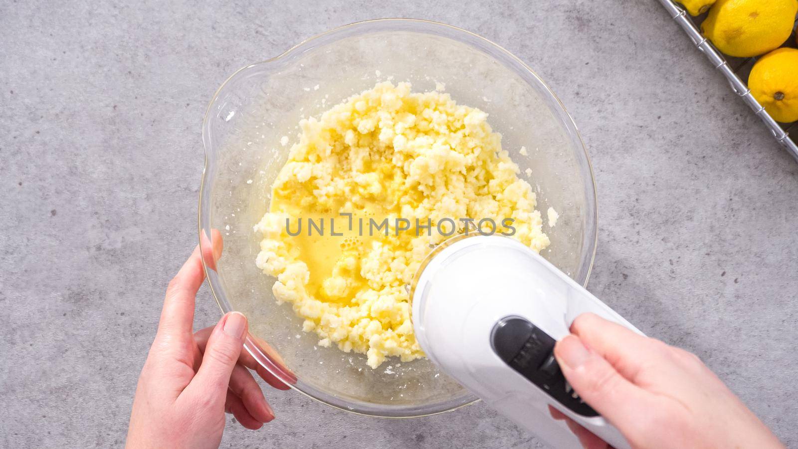 Flat lay. Step by step. Mixing ingredients in a glass mixing bowl to prepare lemon cranberry bundt cake.