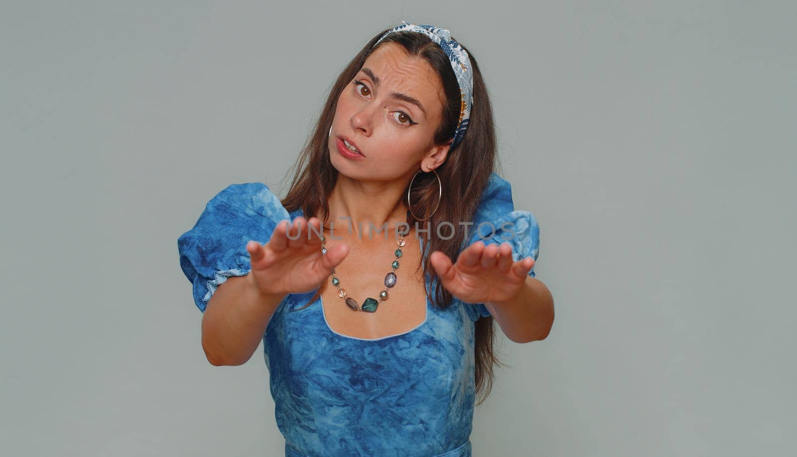 Hey you, be careful. Young woman warning with admonishing finger gesture, saying no, be careful, scolding and giving advice to avoid danger, disapproval sign. Adult stylish girl on gray background