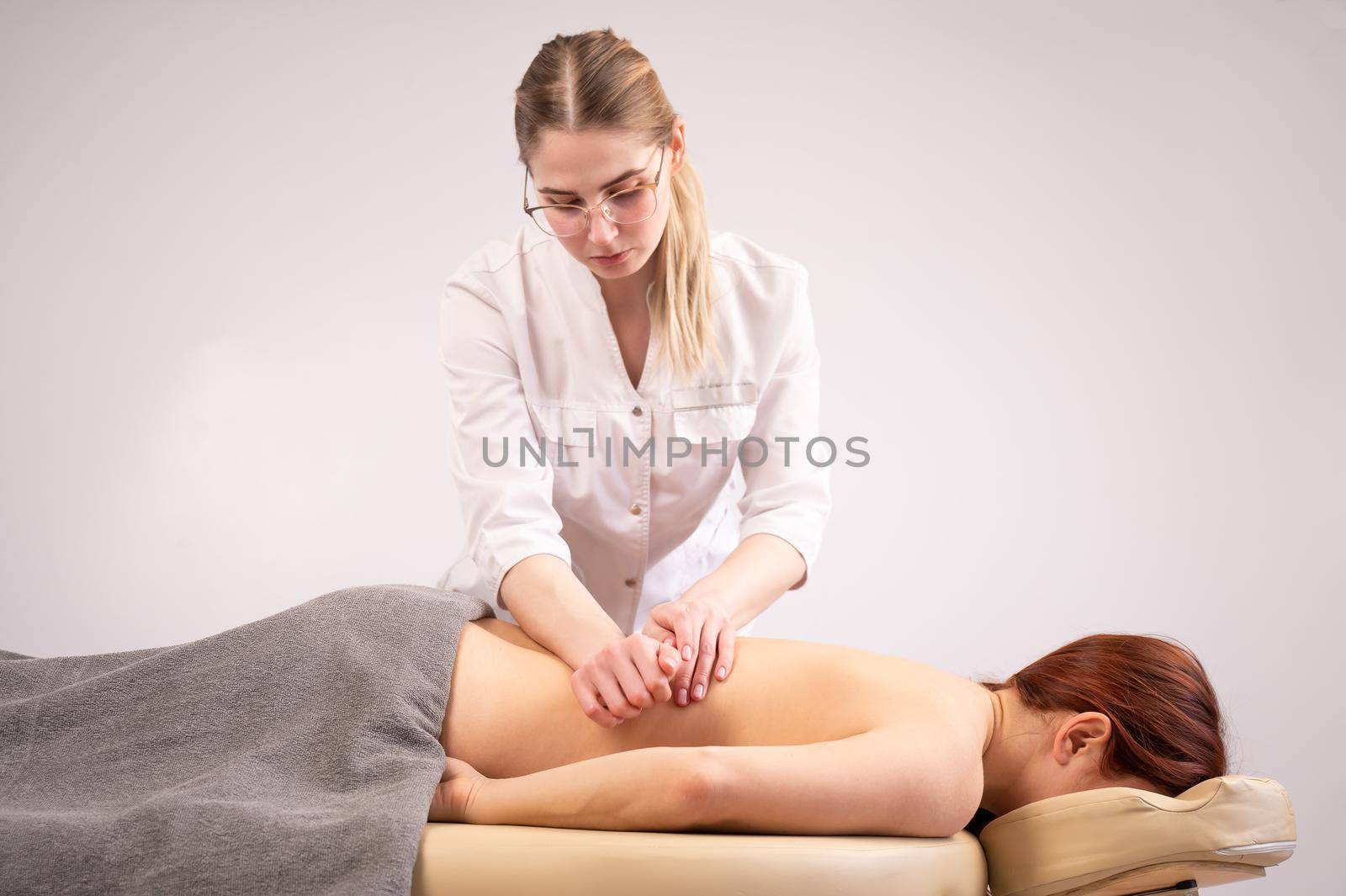 Doctor massaging the back of a female patient