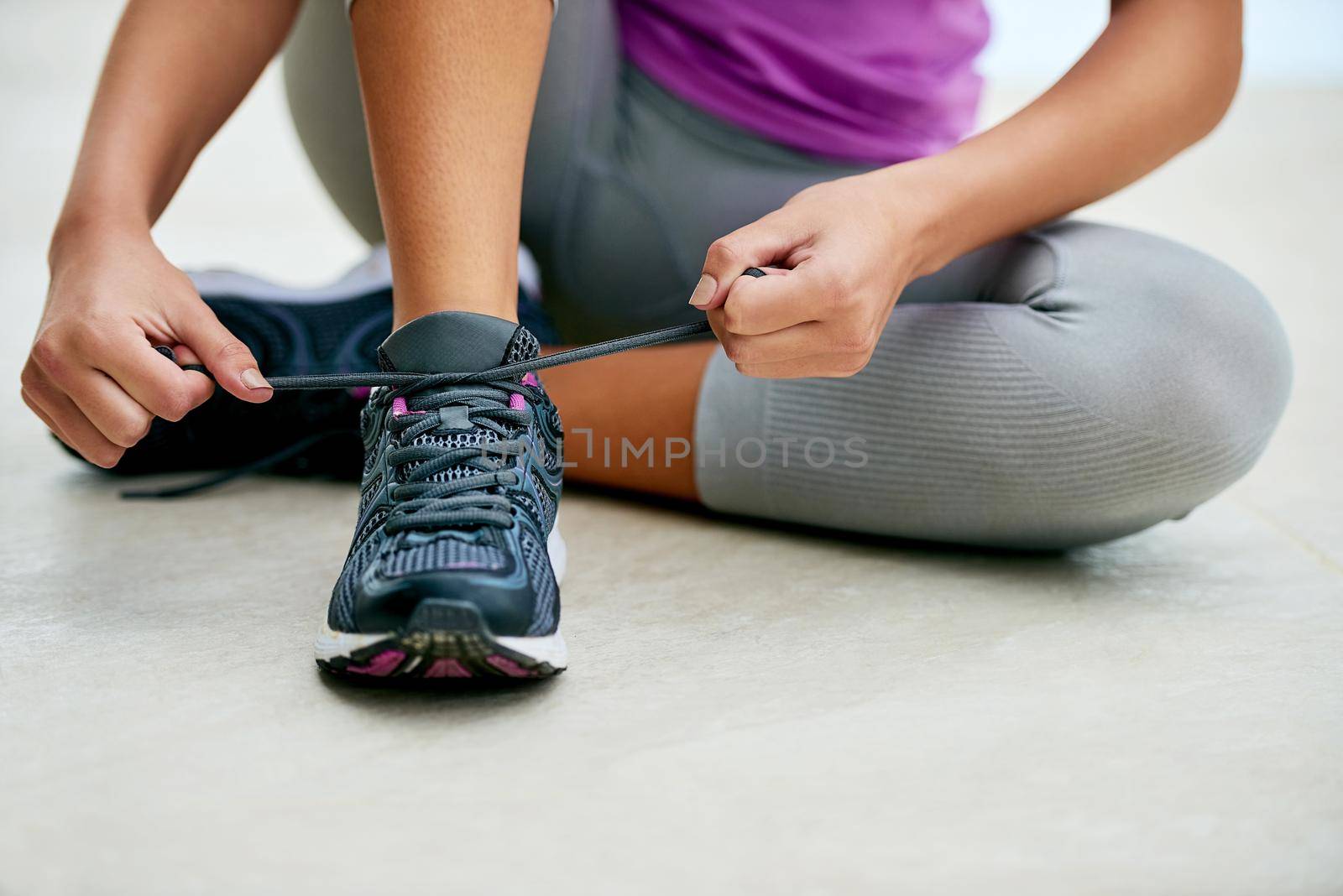 Get ready for a good run. a young woman tying her laces