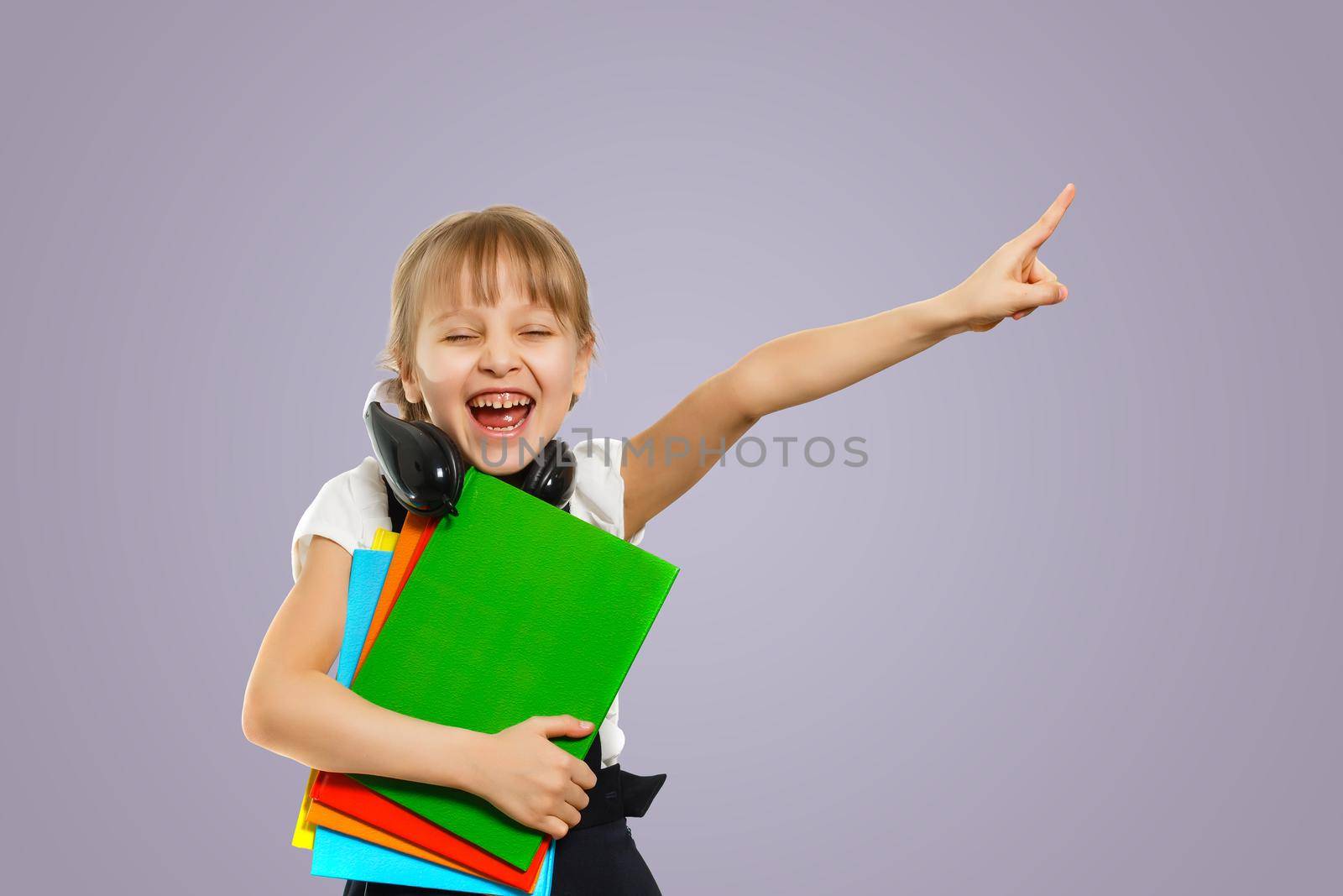 Smiling active excellent best student schoolgirl holding books and going to school wearing bag by Andelov13