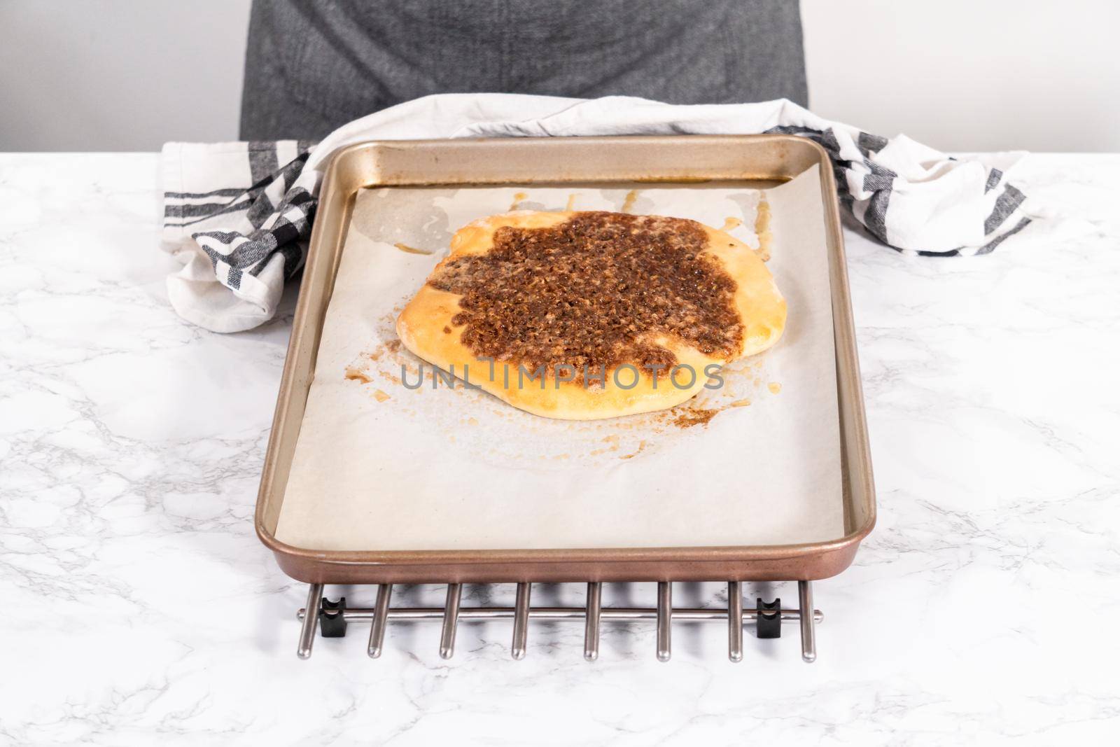 Preparing cinnamon dessert pizza on a baking sheet lined with parchment paper.