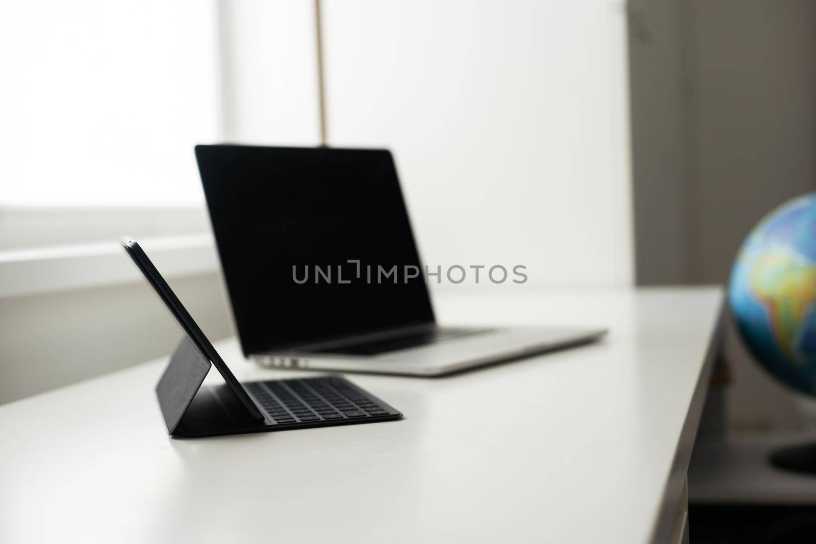 laptop and tablet on a white table by Andelov13