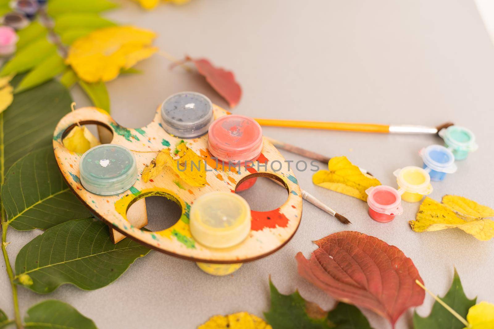 Notepad with watercolor paintings autumn leaves. View of workplace artist . High quality photo