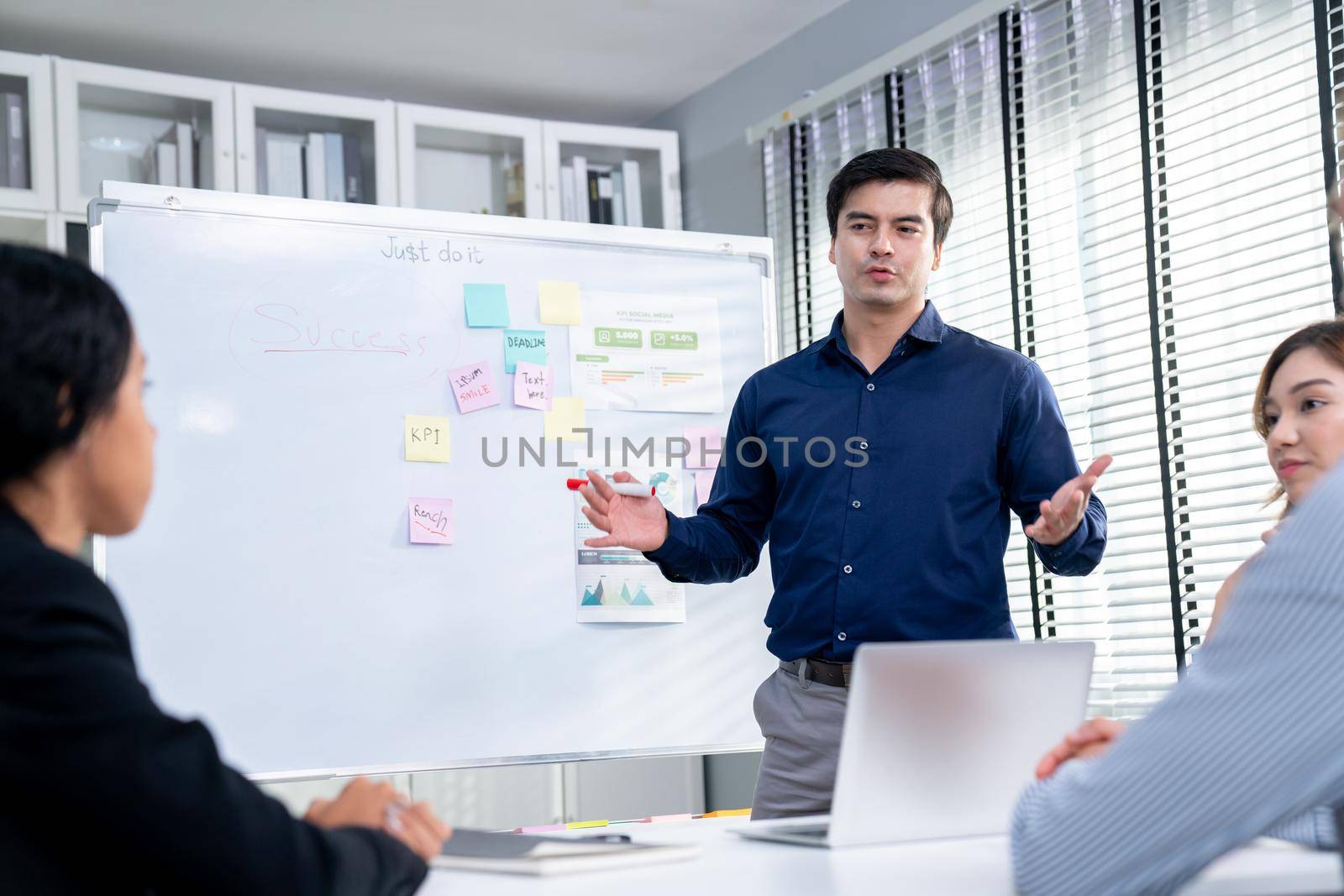 Competent office workers from various nationalities are debating, discussing and brainstorming in the meeting room. A group of employees is collaborating to achieve their business objectives.