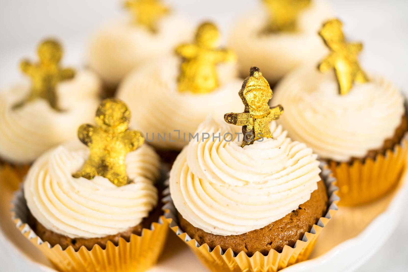 Freshly baked gingerbread cupcakes with eggnog buttercream frosting and topped with a gingerbread man.