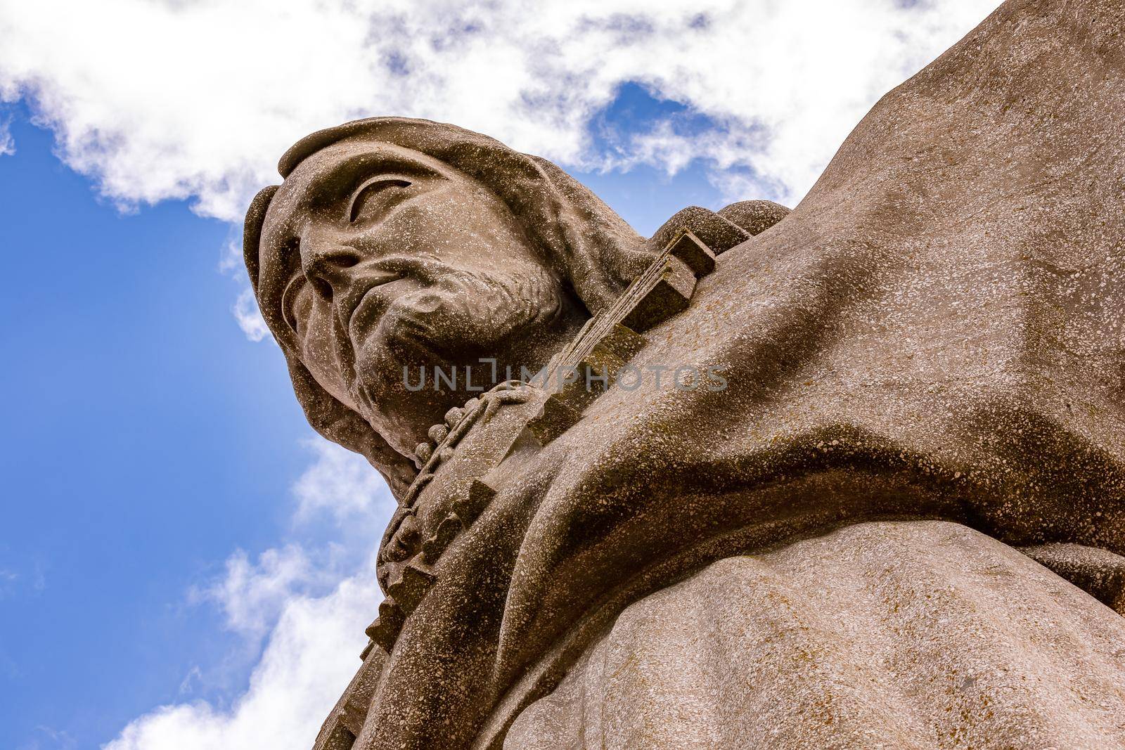 The mighty Christ the Redeemer statue Cristo Rei with head and torso seen from below in Almada near Lisbon, Portugal