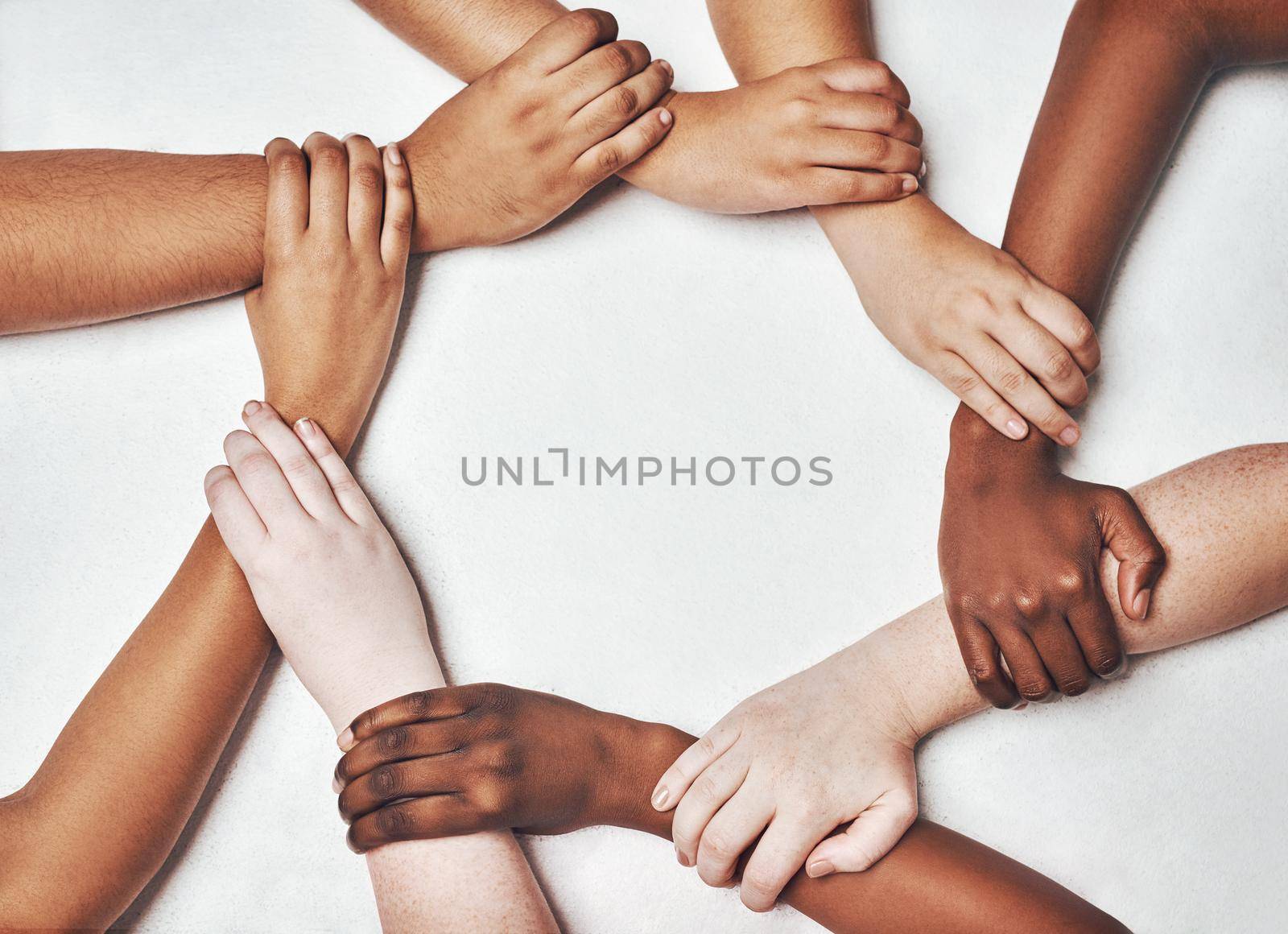 We all need a hand to hold on to. a group of hands holding on to each other against a white background. by YuriArcurs