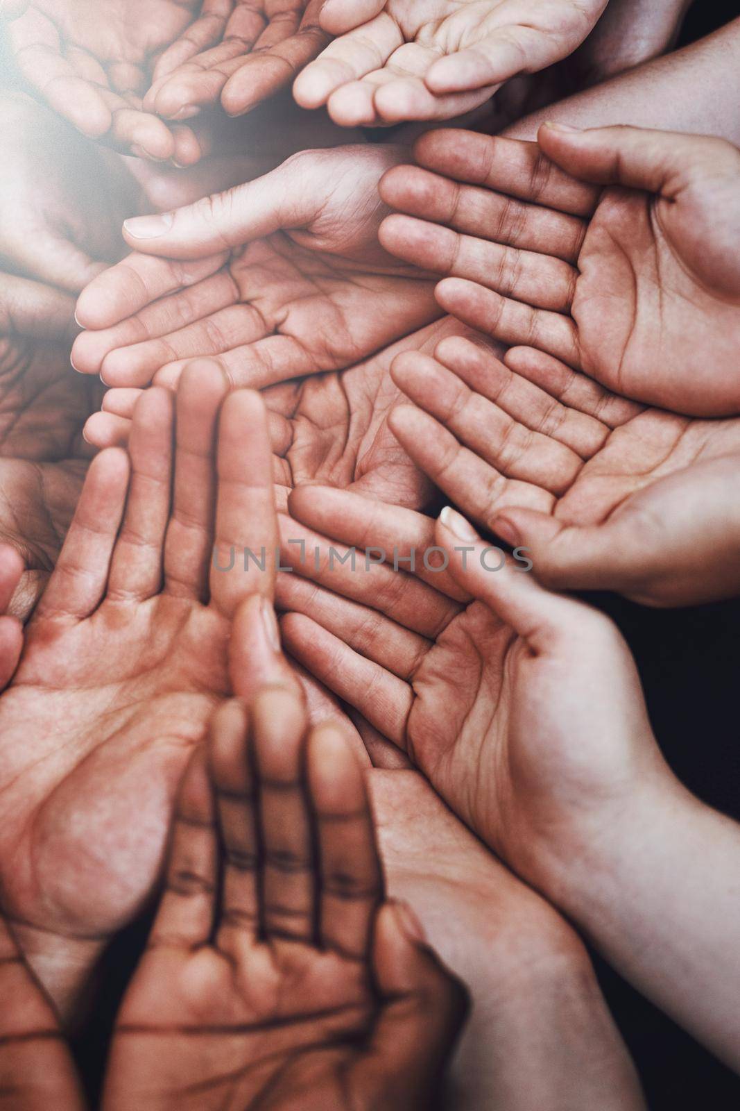 Lend a hand to those who need it. a group of hands held cupped out together. by YuriArcurs