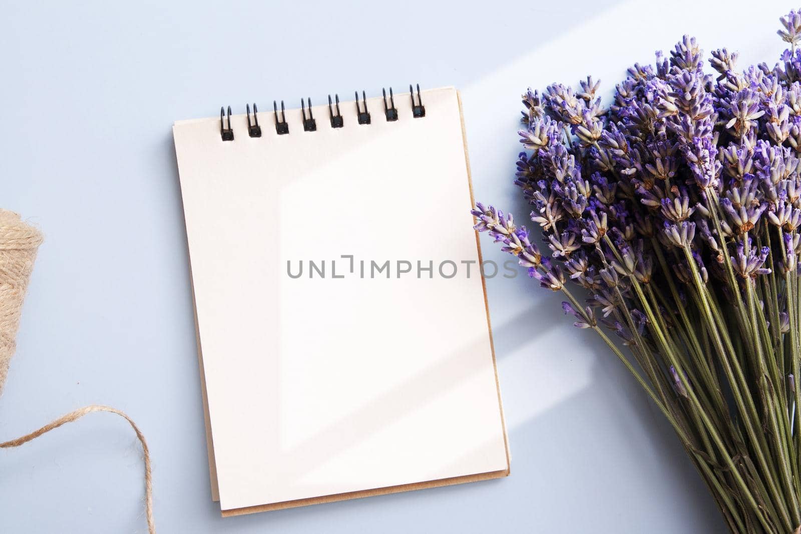 Blank notepad sheet with lavender, candle, twine top view with sunlight. Write your message. High quality photo