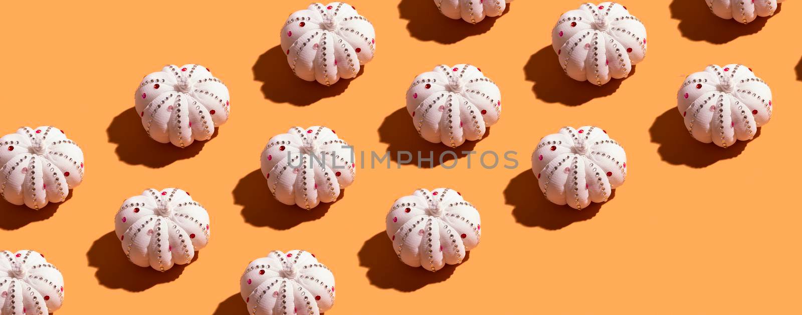 Banner from pattern with white decorative textile pumpkin with shiny stones. Autumn minimal harvest concept. Orange background. by ssvimaliss