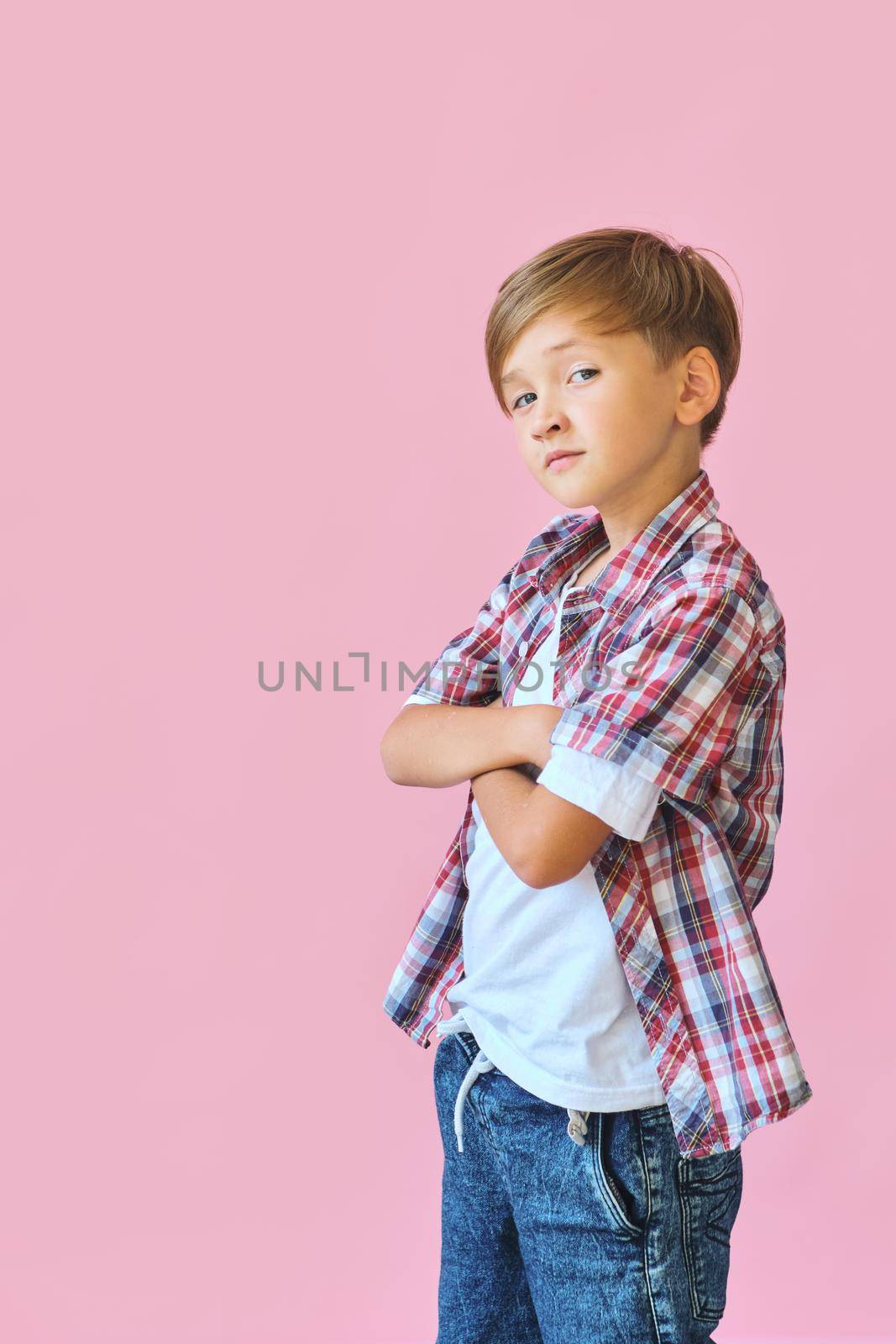 Young happy teen boy with in casuals on pink background. by InnaVlasova