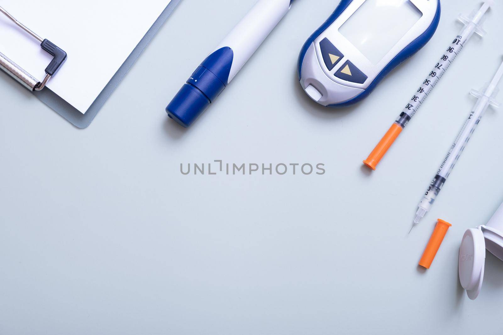 Glucometer and syringes with tablet on color background top view. Means for controlling blood sugar flat lay.