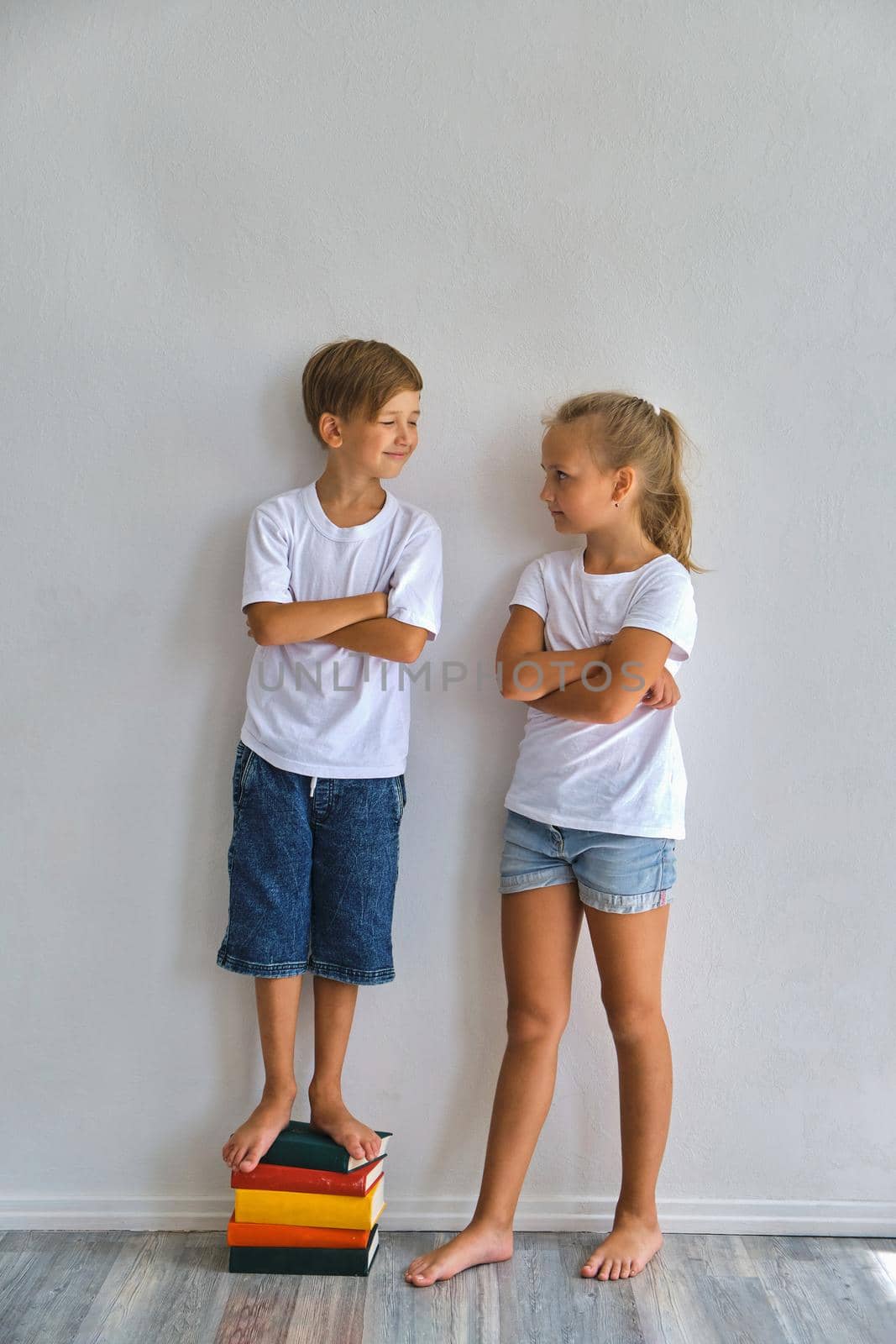 Cool kids, little boy and girl measure their height a by InnaVlasova