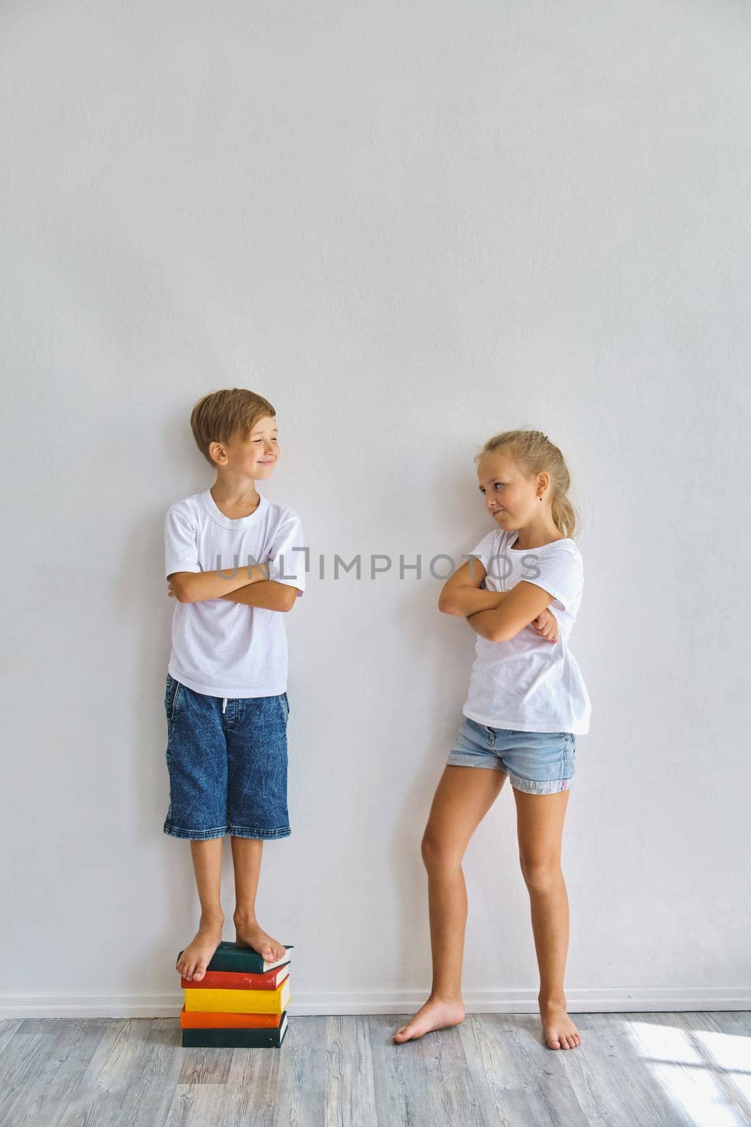 Cool kids, little boy and girl measure their height a by InnaVlasova