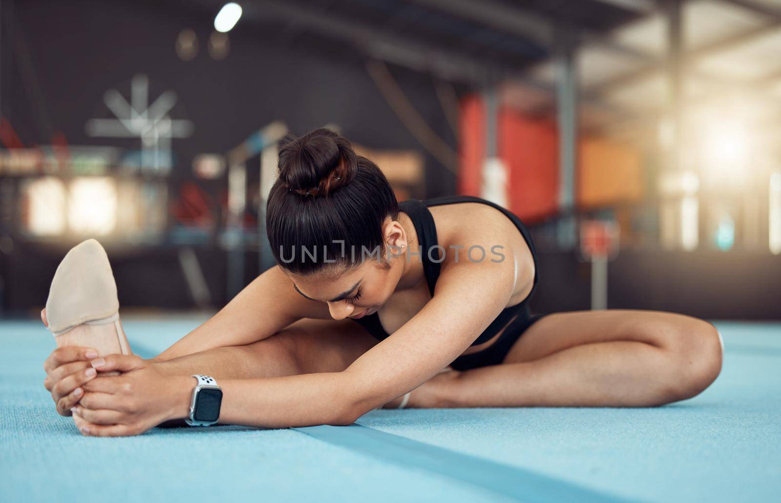 Exercise, fitness and health, woman in a gym, stretching before workout. A girl, gymnast or dancer doing yoga or pilates to start training. Motivation, wellness and sports for healthy, fit lifestyle.