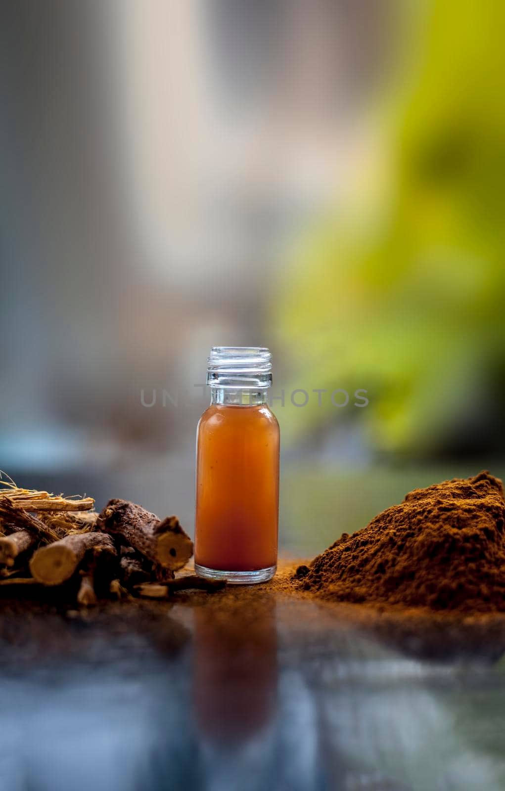 Shot of Rheum emodi or Revand Chini along with its extracted root essence and raw powder on a black glossy surface.