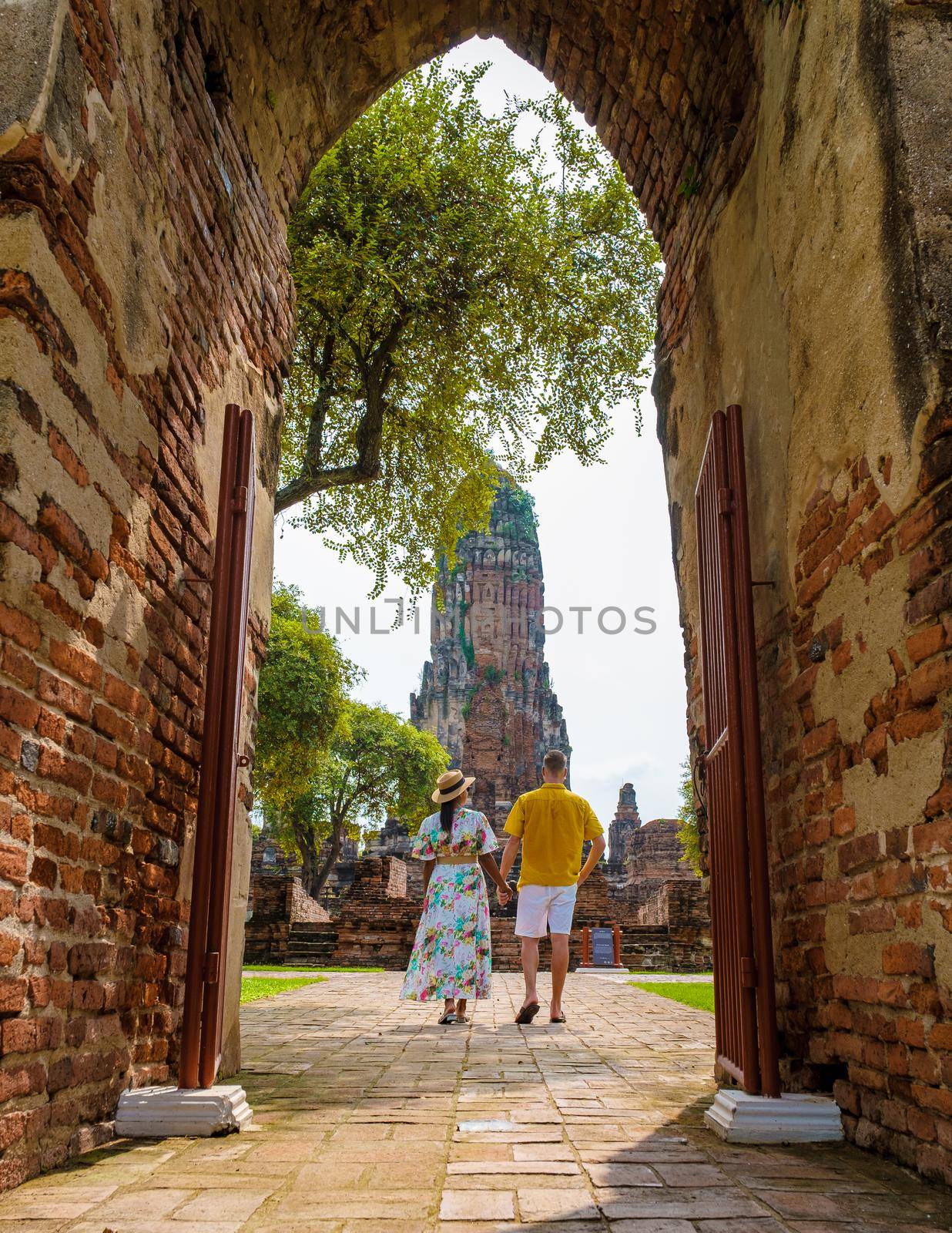 Ayutthaya, Thailand at Wat Phra Ram, a couple of men and women with a hat visiting Ayyuthaya Thailand. Tourist with map in Thailand