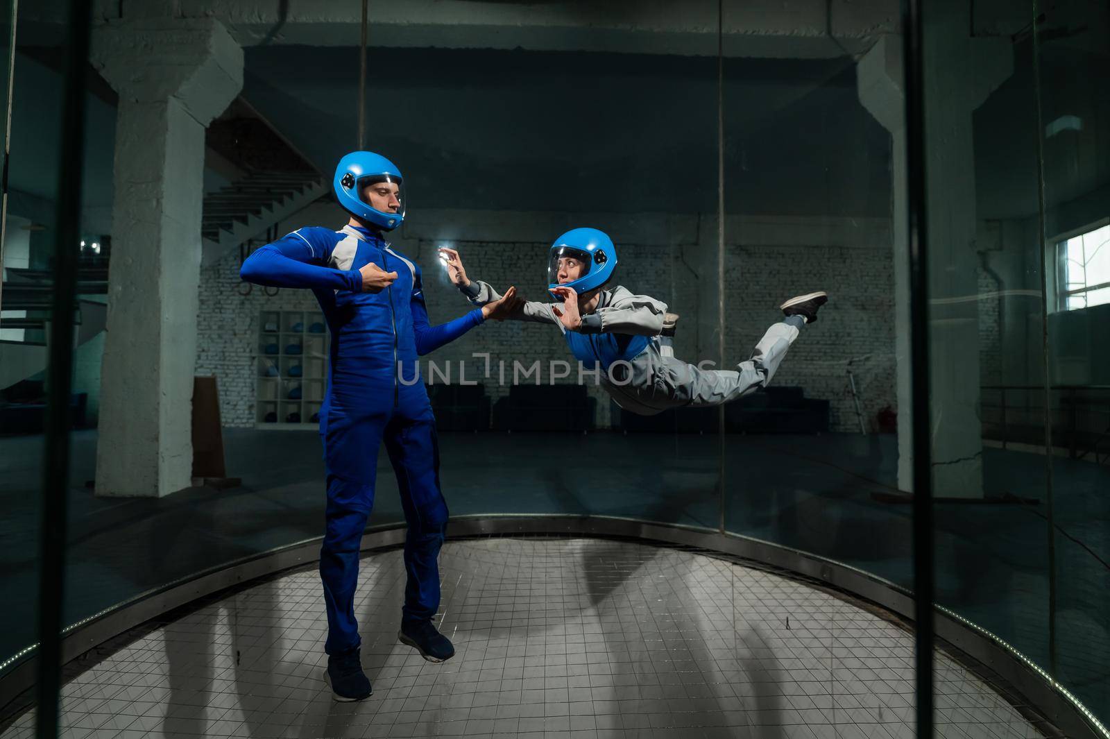 A man teaches a woman how to fly in a wind tunnel. Free fall simulator. by mrwed54