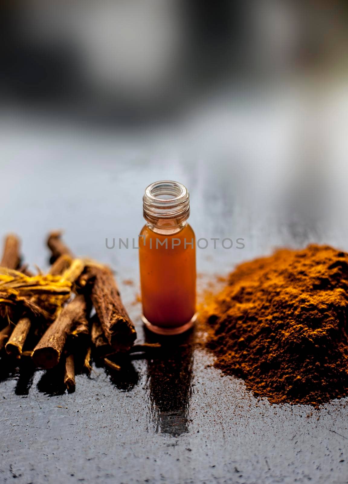 Shot of Rheum emodi or Revand Chini along with its extracted root essence and raw powder on a black glossy surface.