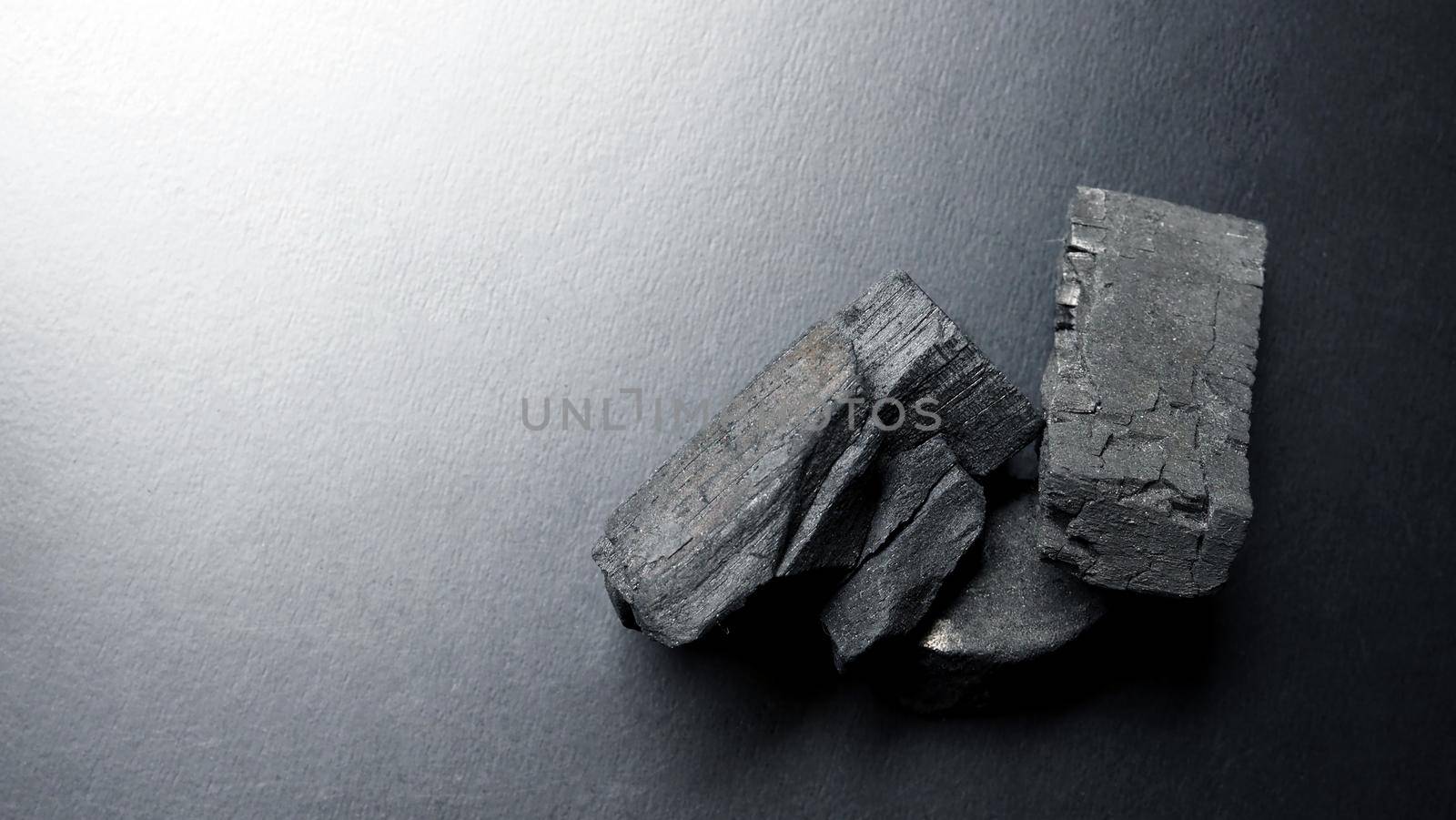 Close-up images of black color charcoal on black background that made from natural wood which represent energy power concept or healthy or use for absorb odor in the room or refrigerator.