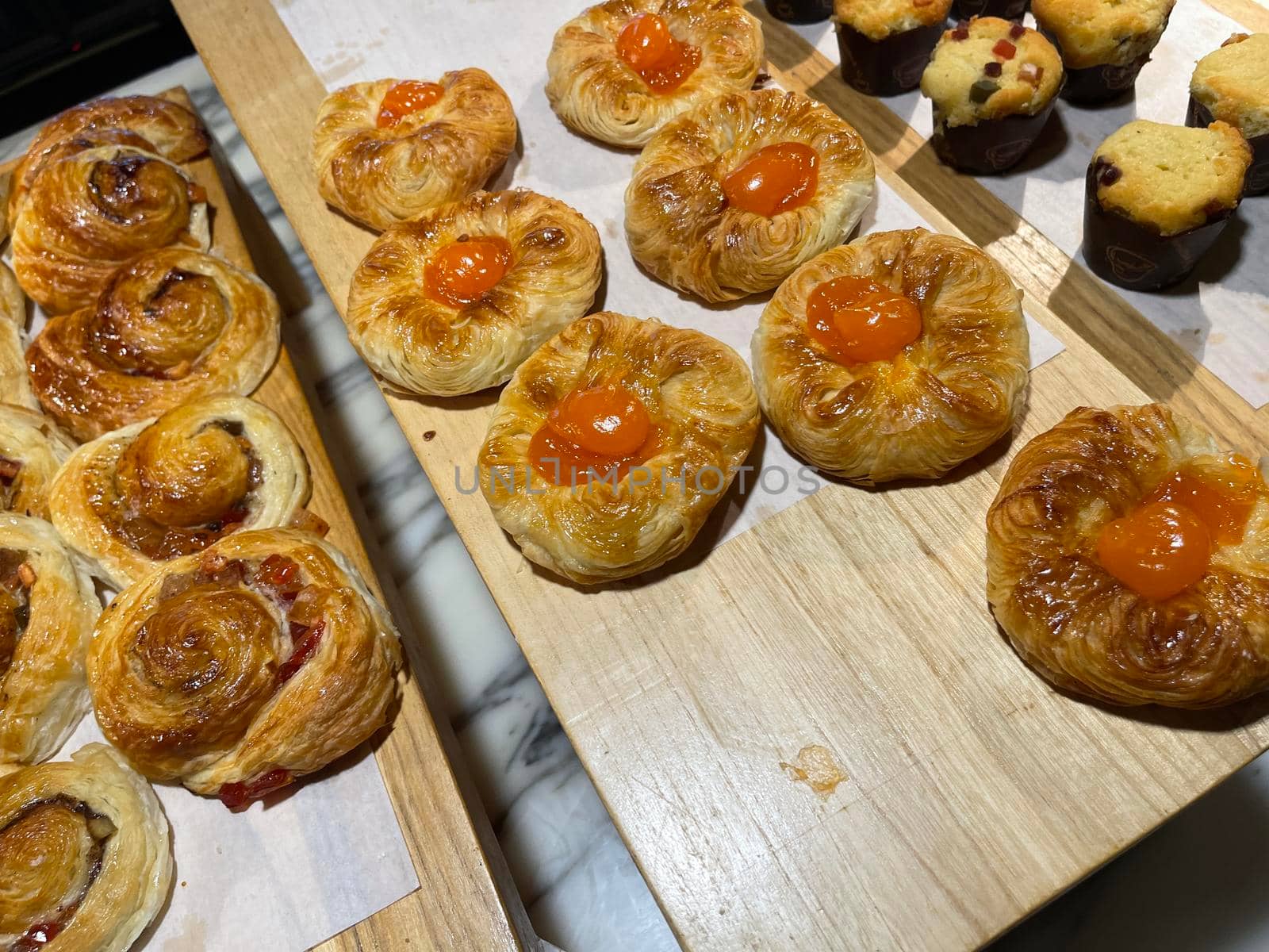 Lines of fresh baked sweet puff pastry stuffed with apricot and peach jelly, super delicious warm fresh buttery sweet puff pastry stuffed with apricot and peach, French and American baked pastries are enjoyed world wide on bakery shop, tasty multiple sweet puff pastry stuffed with apricot and peach