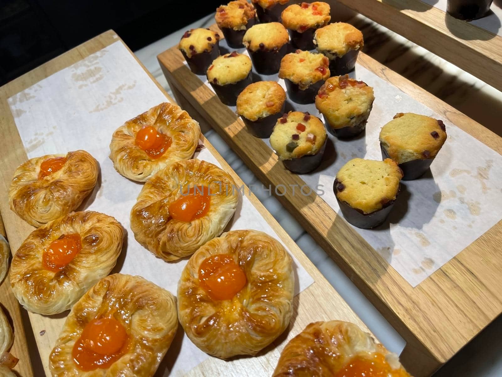 Lines of fresh baked sweet puff pastry stuffed with apricot and peach jelly, super delicious warm fresh buttery sweet puff pastry stuffed with apricot and peach, French and American baked pastries are enjoyed world wide on bakery shop, tasty multiple sweet puff pastry stuffed with apricot and peach