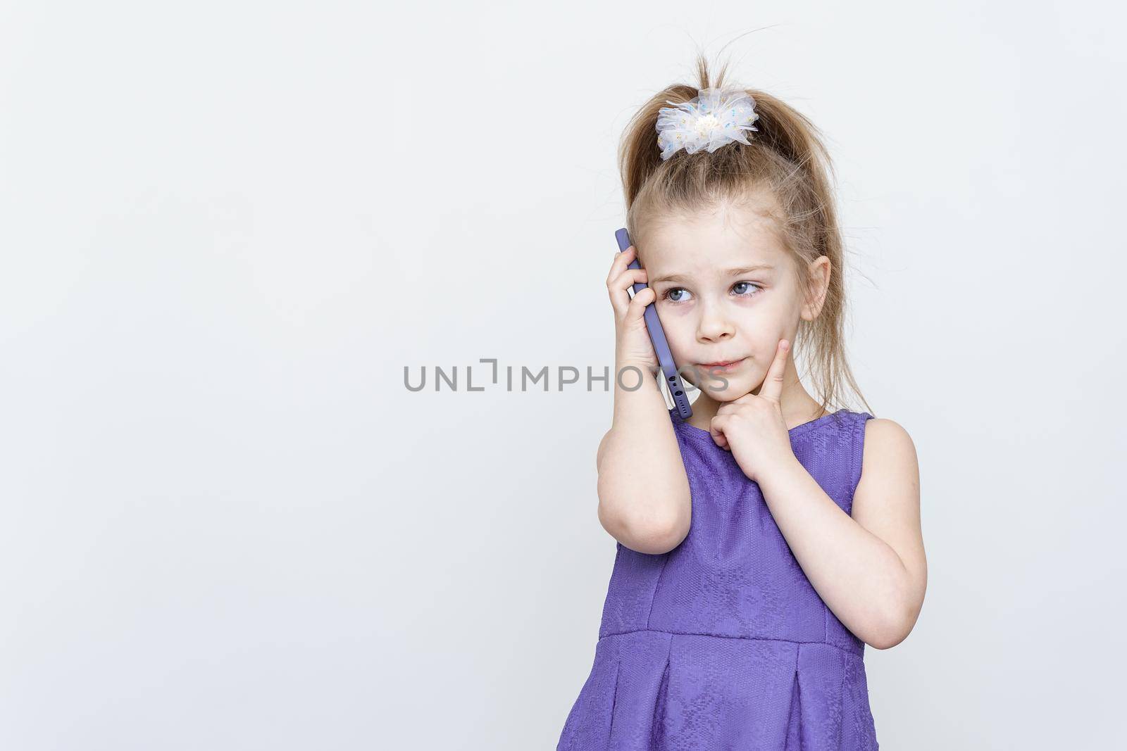 kid posing in the studio with a smartphone by Lena_Ogurtsova