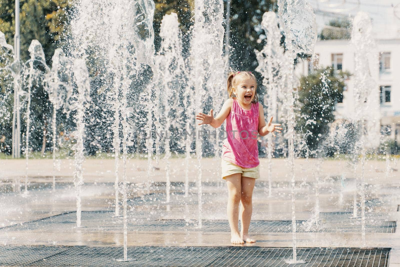 child girl playing in the water jets of the fountain by Lena_Ogurtsova