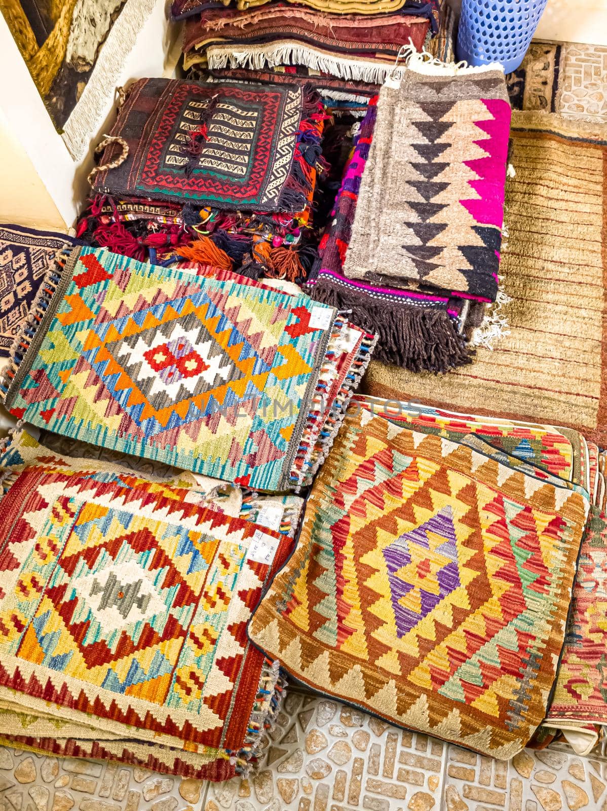 Ethnic carpet, ornamental folk bags, many ornate pillows with embroidery in asian shop, store. Asian market, trade fair in Uzbekistan. Traditional national ornament. Asian handicraft, Uzbek craft by Milanchikov