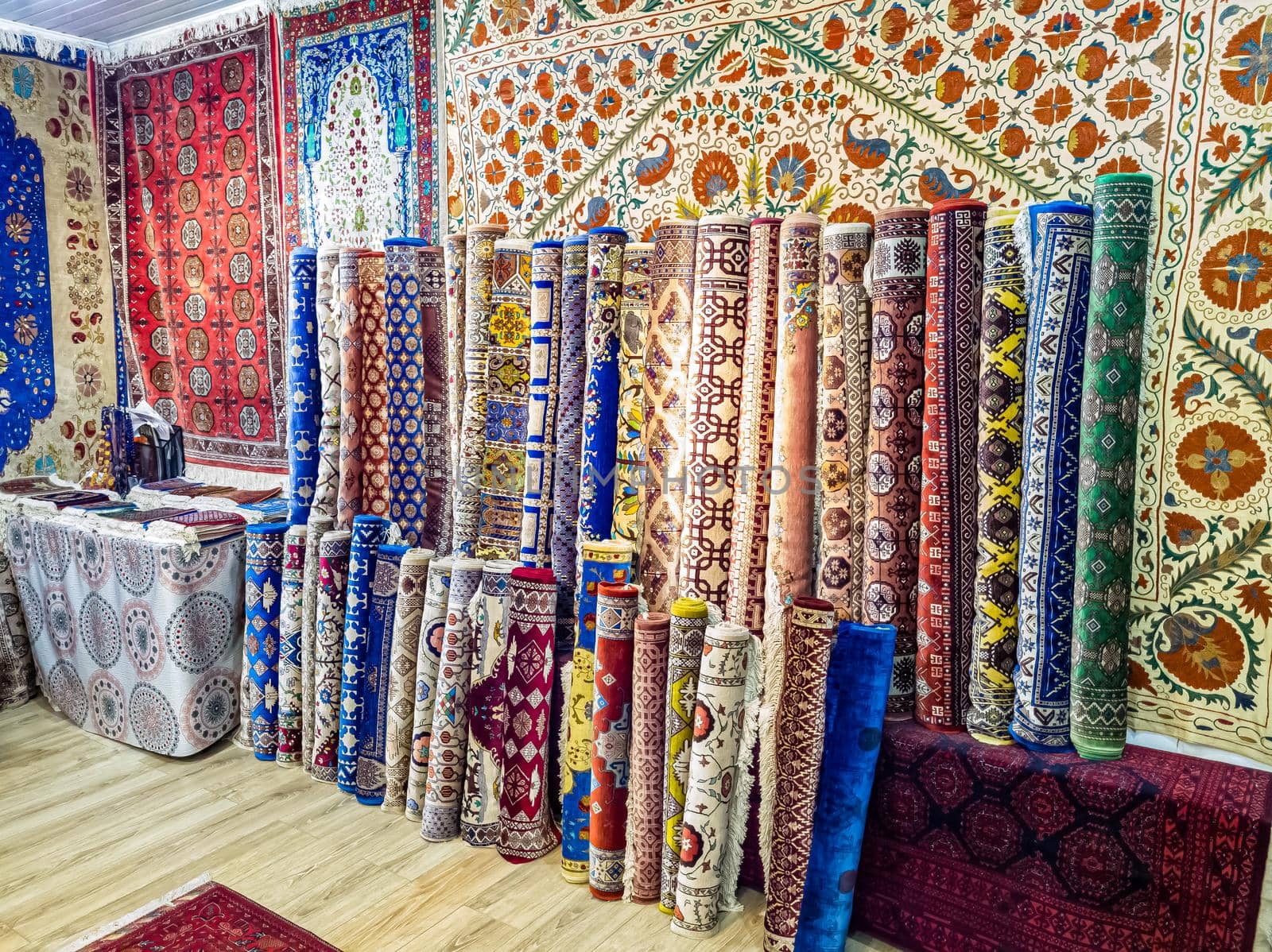 Ethnic carpet, ornamental folk bags, many ornate pillows with embroidery in asian shop, store. Asian market, trade fair in Uzbekistan. Traditional national ornament. Asian handicraft, Uzbek craft.
