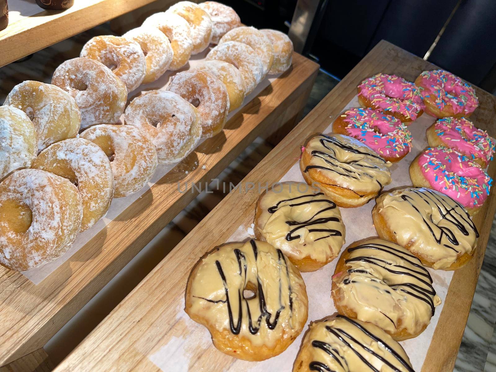 Lines of fresh delicious donuts on bakery shop, tasty multiple donuts, Selective focus donuts with various topping