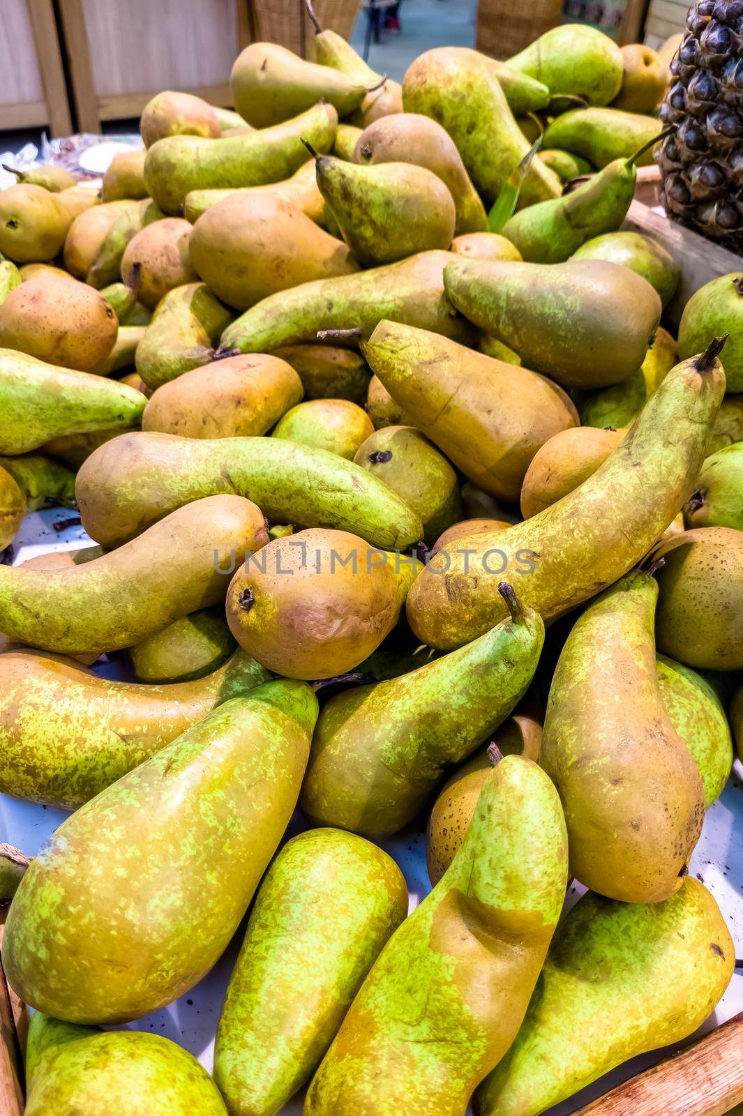 Yellow pear fruits on the counter in the store. Fruit trade in a retail network. Close-up