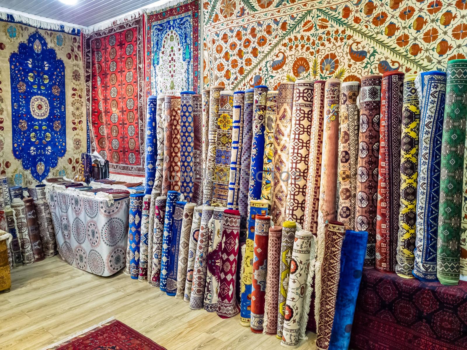 Ethnic carpet, ornamental folk bags, many ornate pillows with embroidery in asian shop, store. Asian market, trade fair in Uzbekistan. Traditional national ornament. Asian handicraft, Uzbek craft by Milanchikov