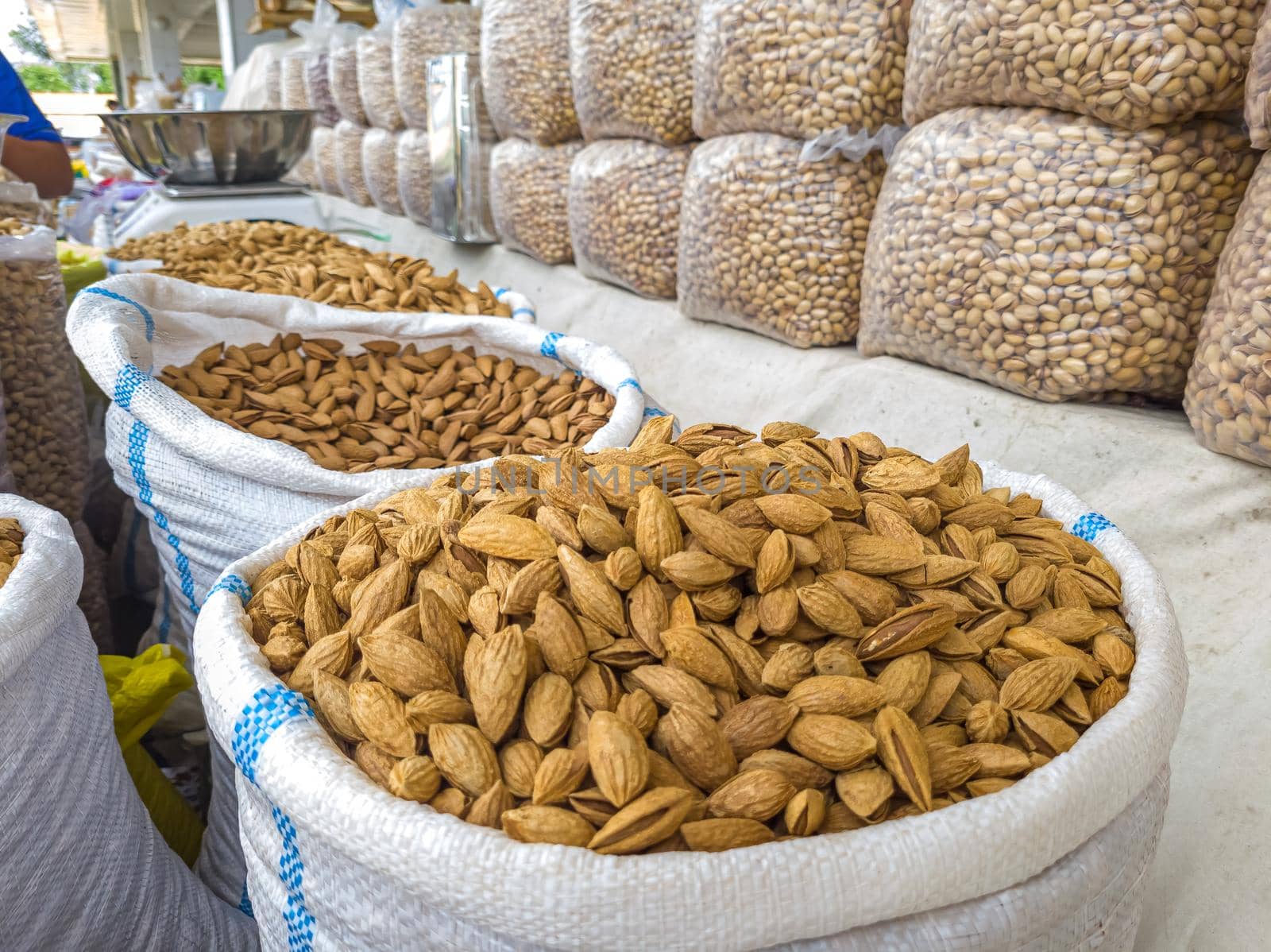 Oriental Bazaar. Almond peeled and unpeeled, nuts sales in market. Dry food, variety almonds in store. Concept of healthy eating, raw product, bazaar, diet, almond theme by Milanchikov