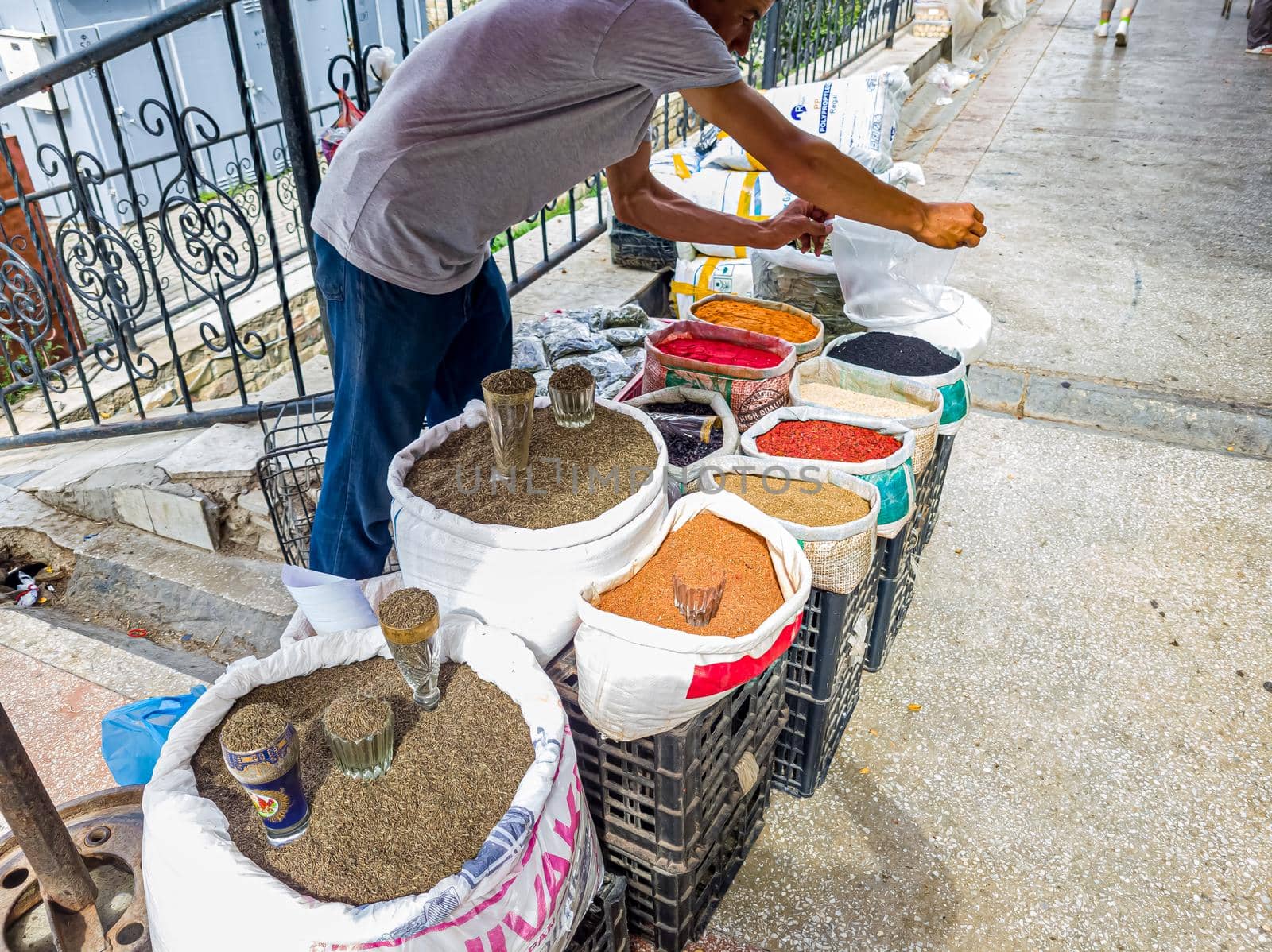 Street seller of spices by weight with bags in Uzbekistan.