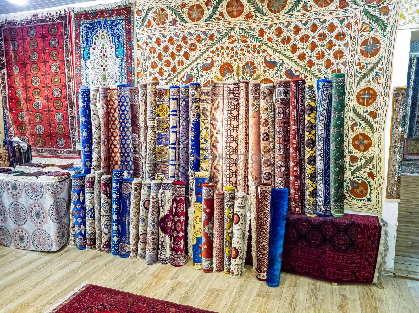 Ethnic carpet, ornamental folk bags, many ornate pillows with embroidery in asian shop, store. Asian market, trade fair in Uzbekistan. Traditional national ornament. Asian handicraft, Uzbek craft by Milanchikov