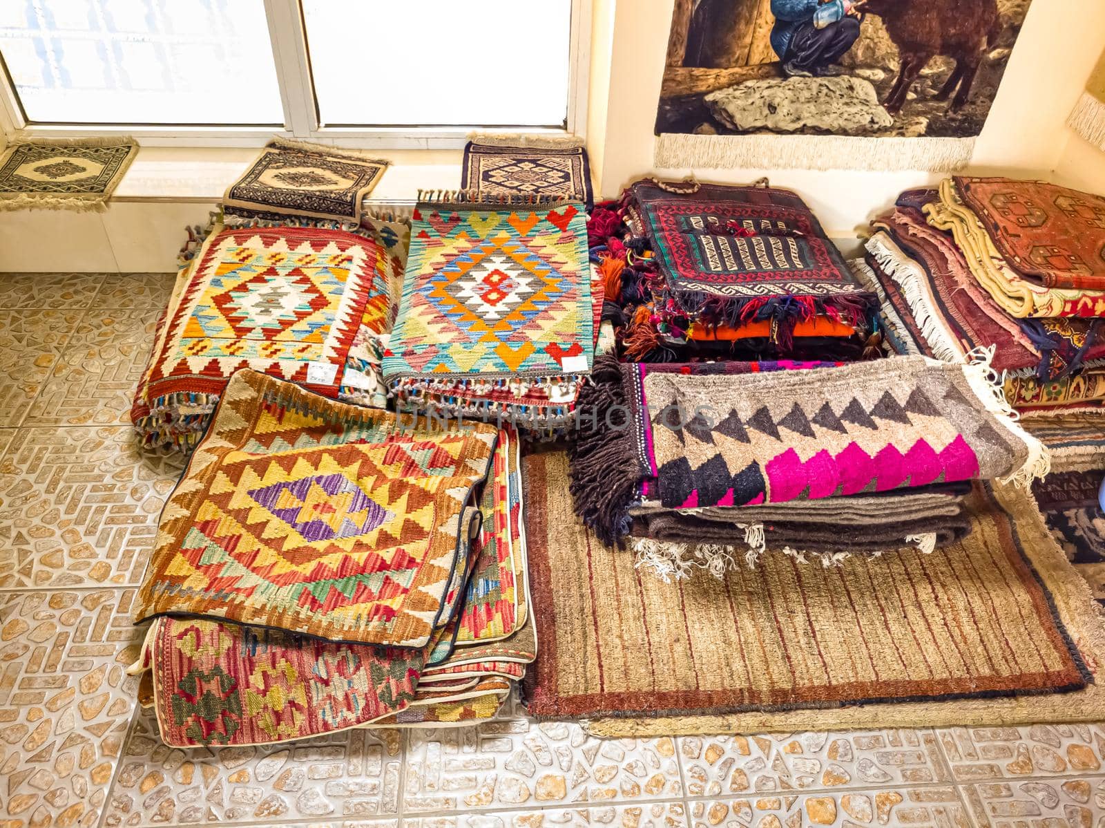 Ethnic carpet, ornamental folk bags, many ornate pillows with embroidery in asian shop, store. Asian market, trade fair in Uzbekistan. Traditional national ornament. Asian handicraft, Uzbek craft.