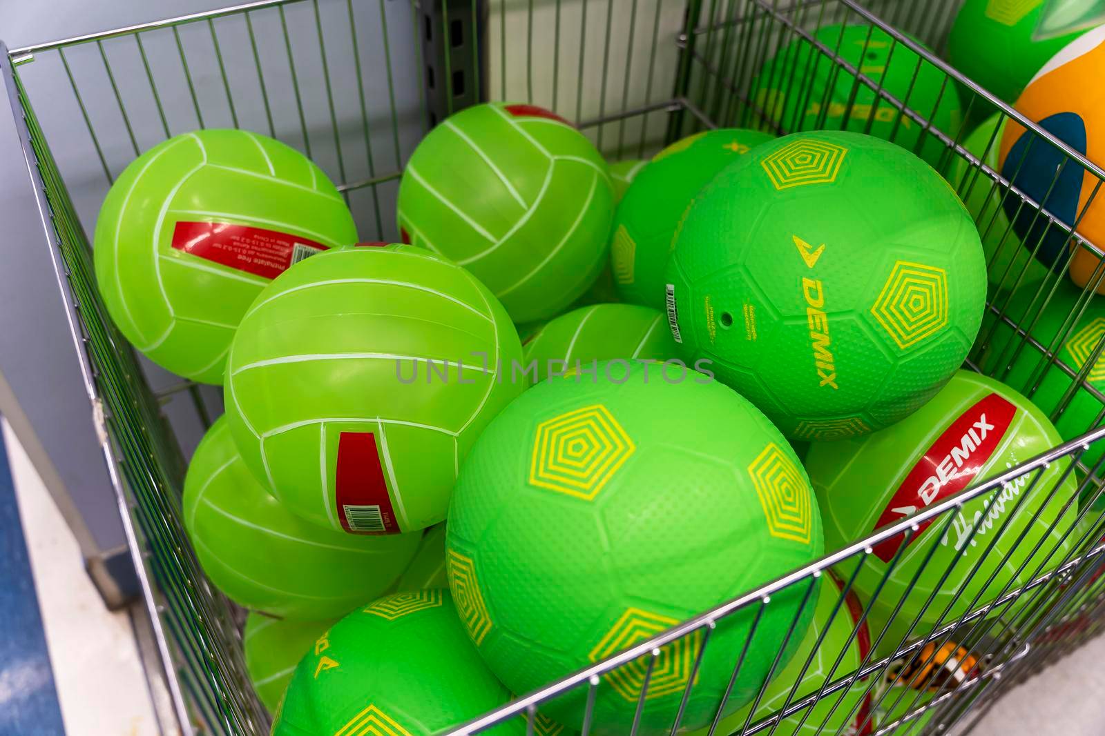 SAINT PETERSBURG, RUSSIA - AUGUST 14, 2022: new volleyball and soccer balls in the basket of a sporting goods store. colorful sports equipment in the sports store