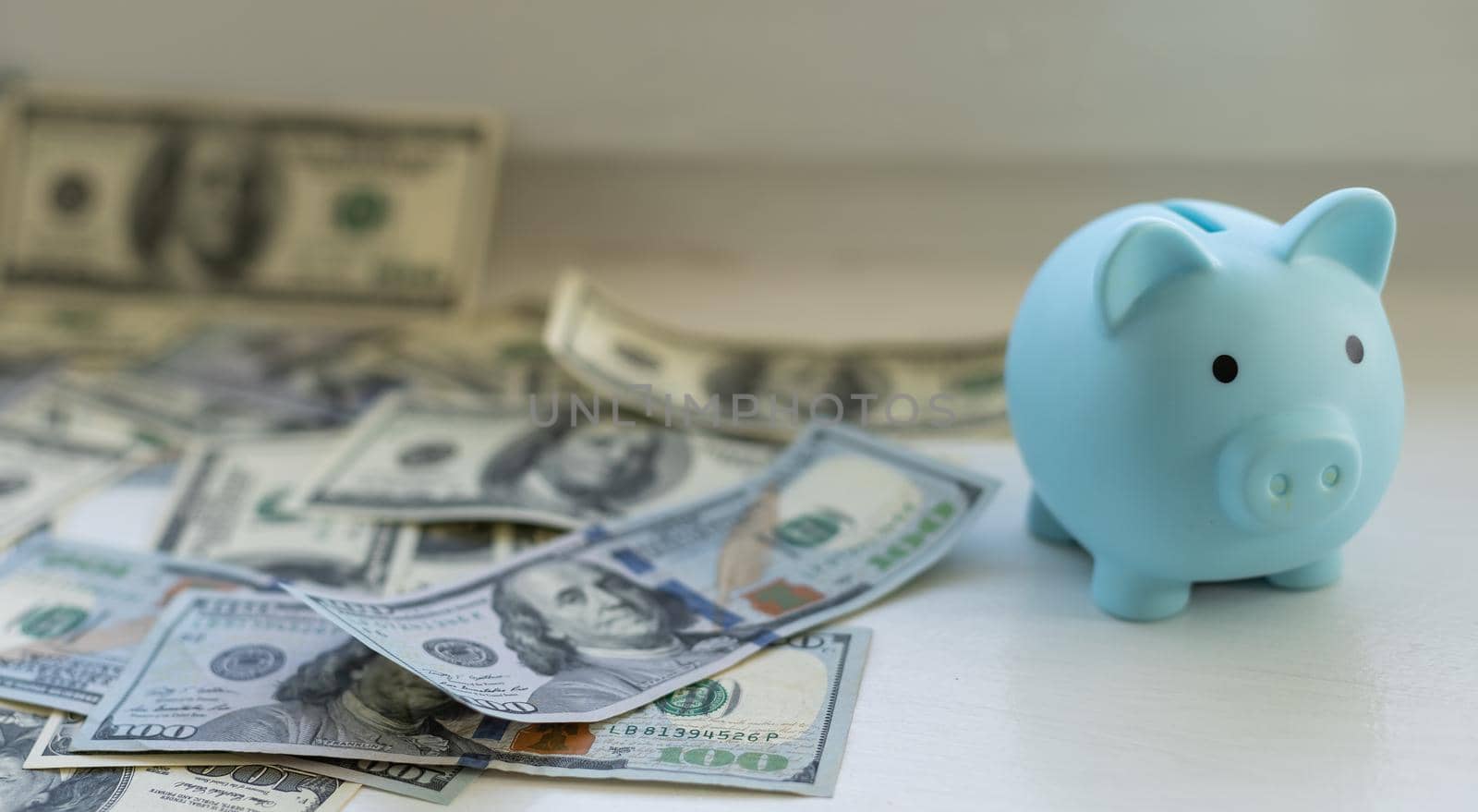 business, finance, investment, saving and corruption concept - close up of dollar cash money and piggy bank on table by Andelov13