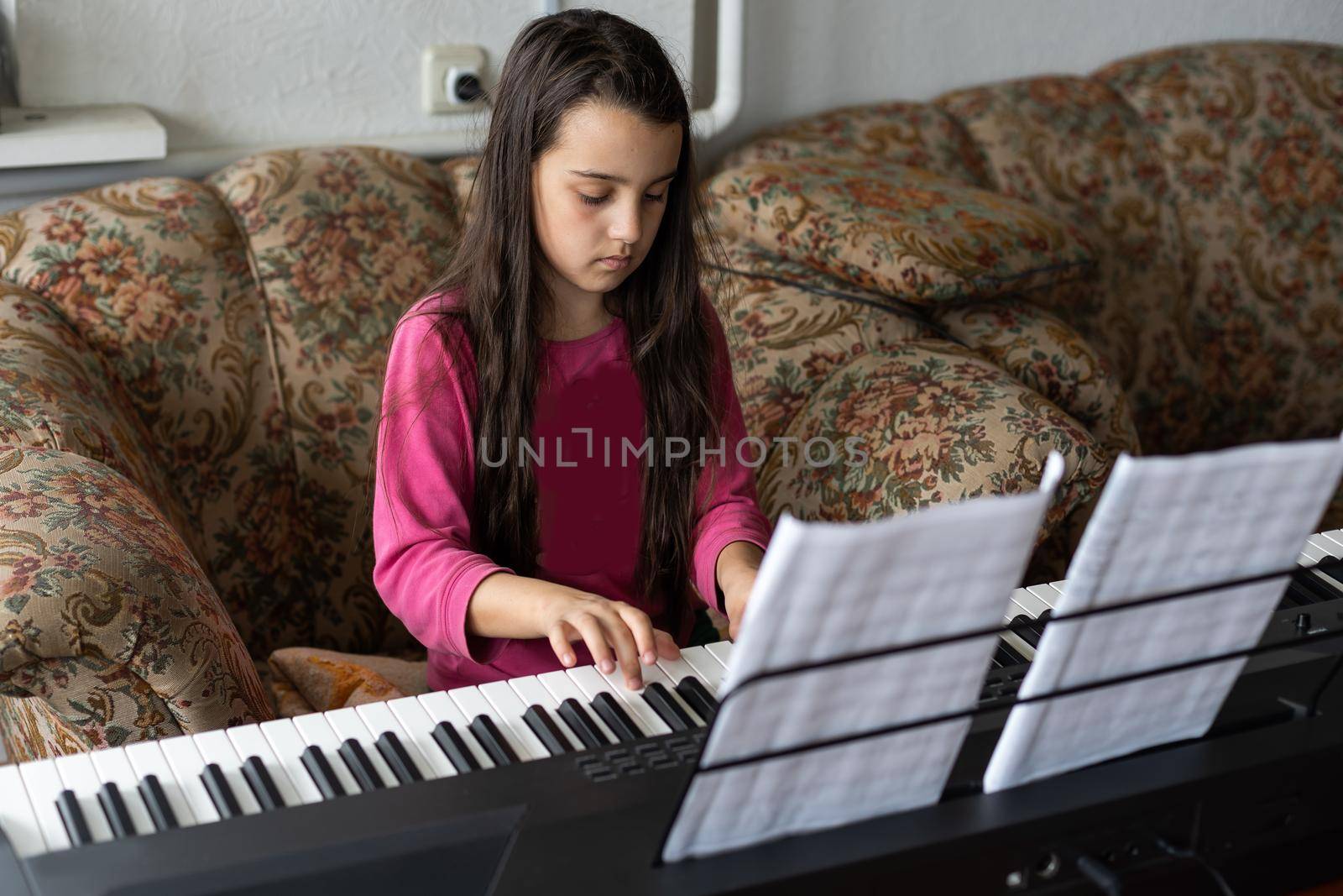 little girl playing on a new synthesizer in the old room.