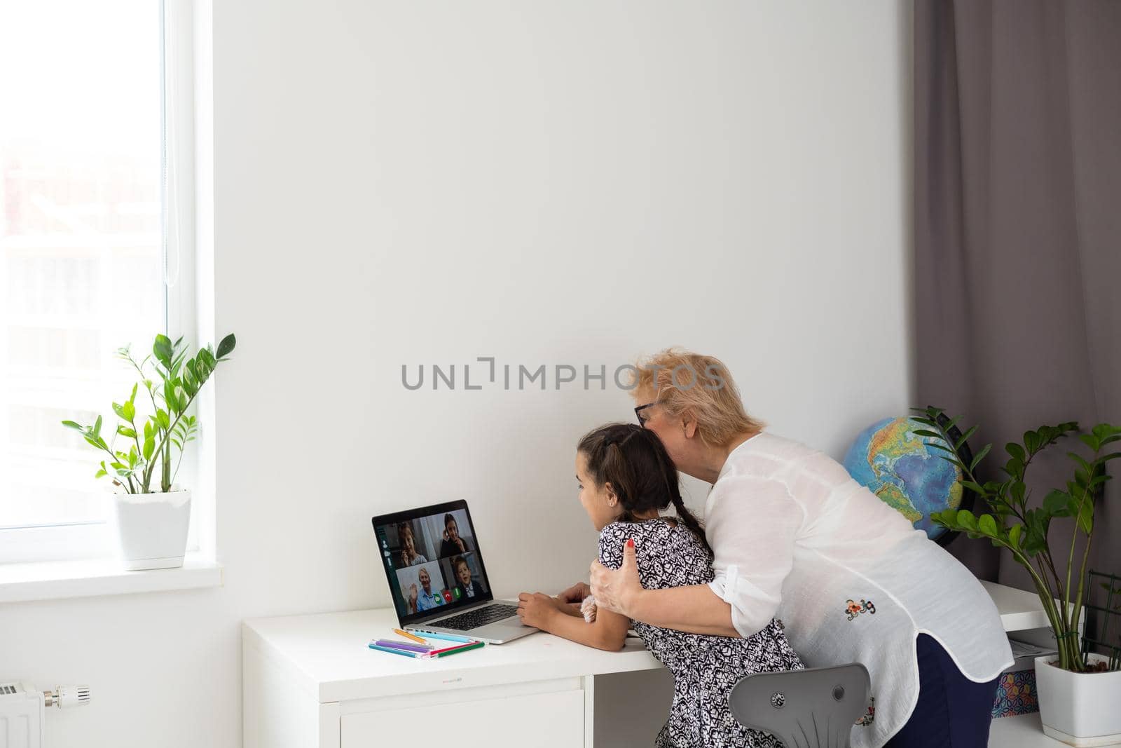 Grandmother and granddaughter using tablet and laptop